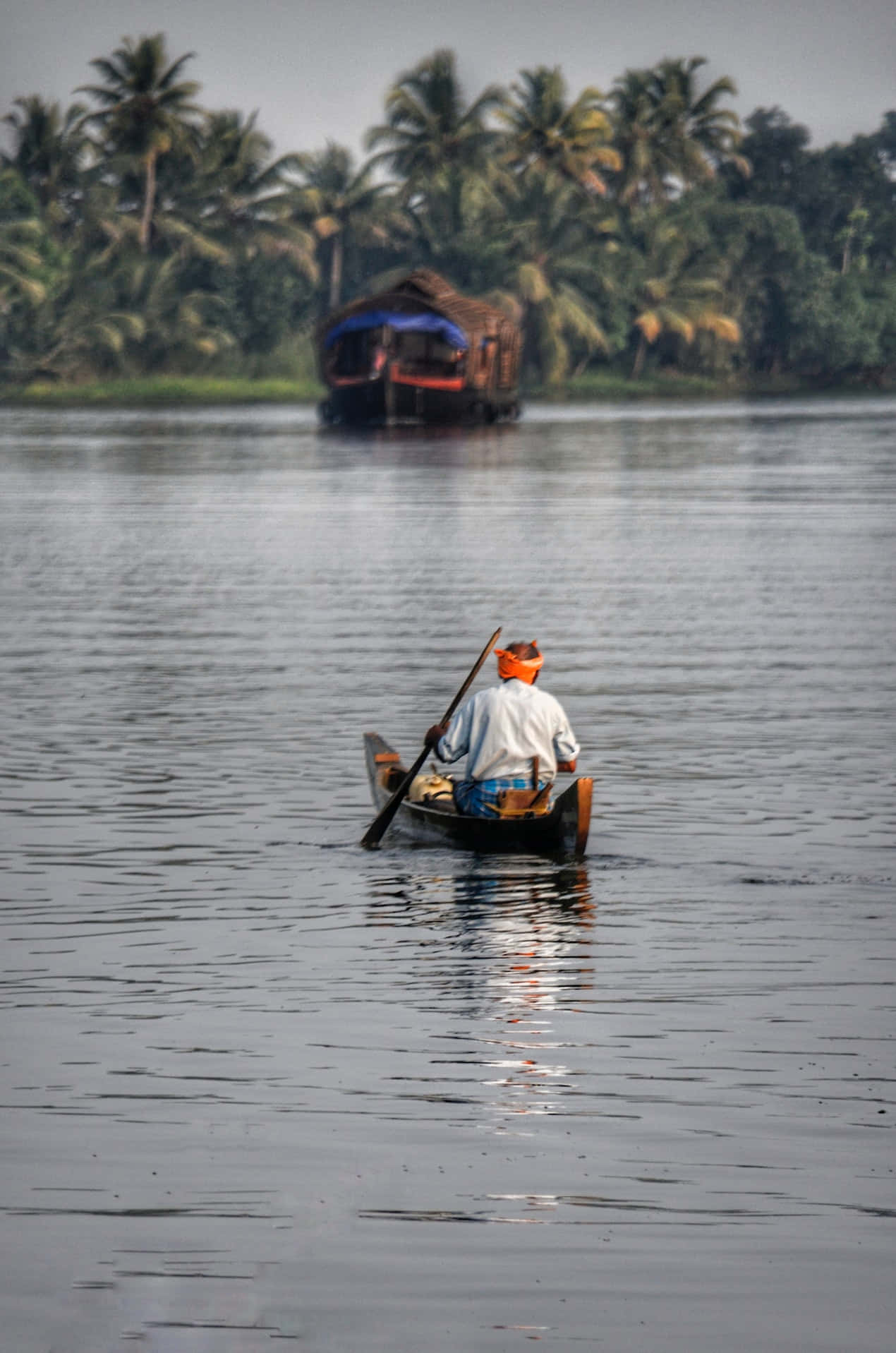 A Man Is Paddling A Canoe On A Lake