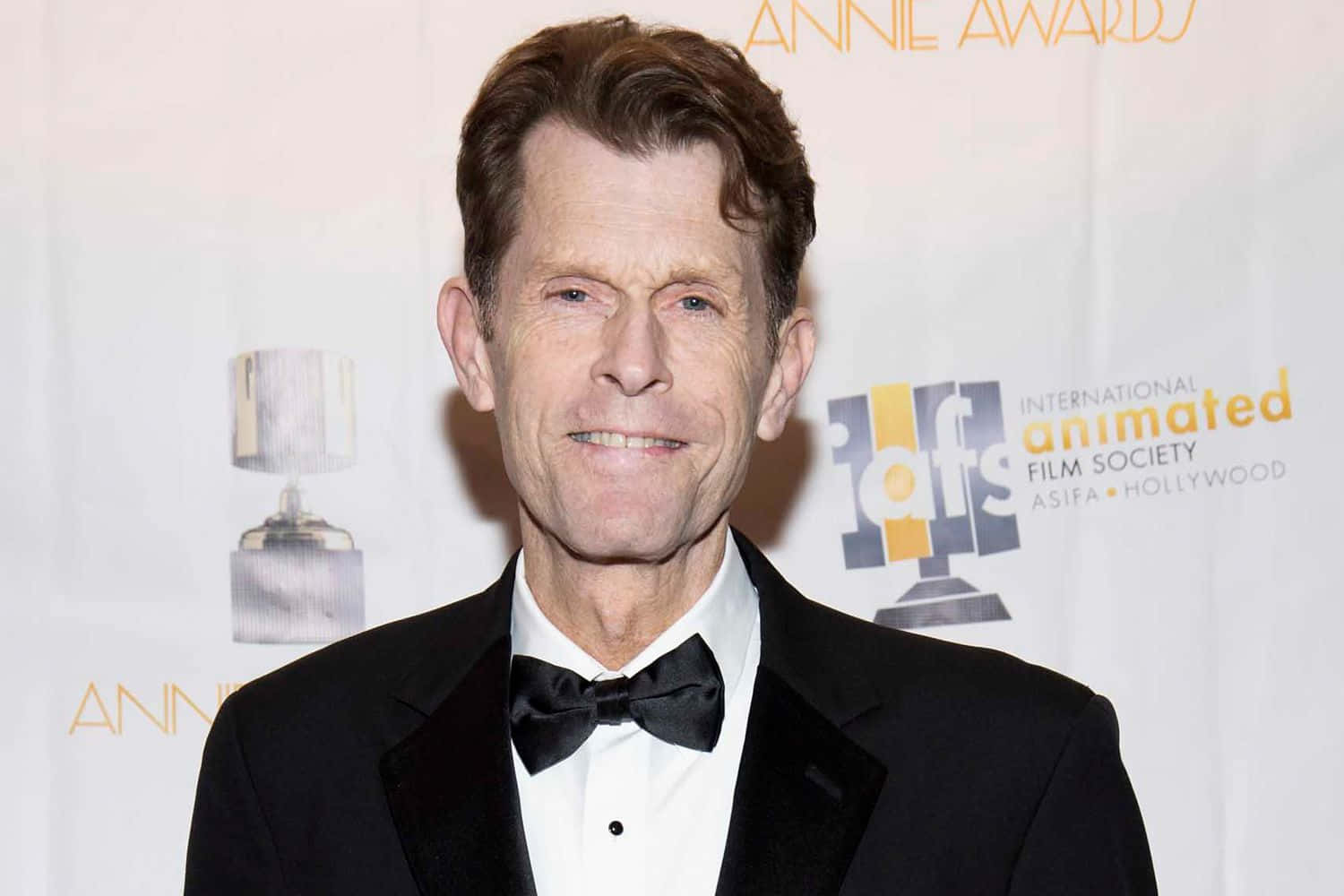 Kevin Conroy, the legendary voice actor, speaking at an event. Wallpaper
