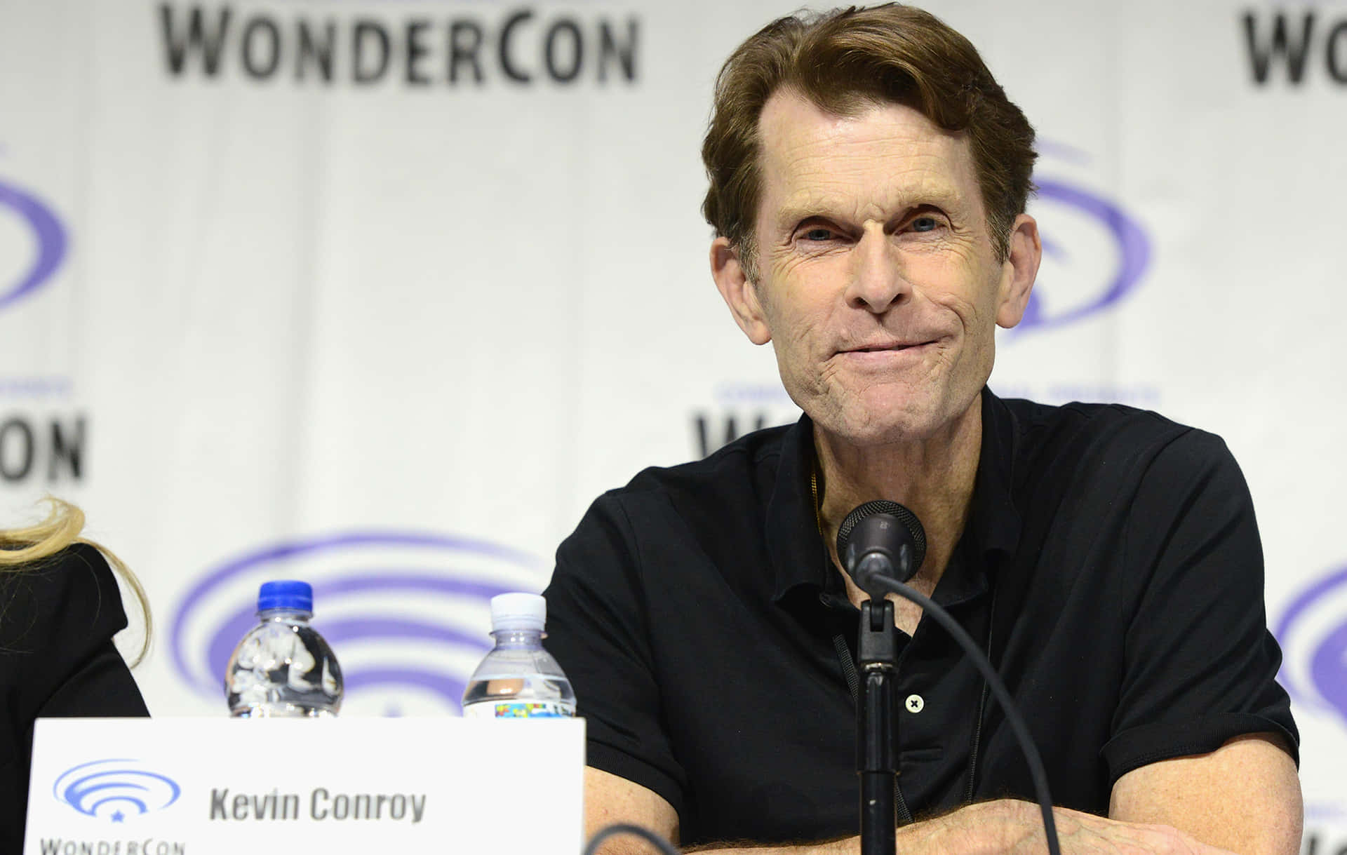 Kevin Conroy with a microphone in a sound booth Wallpaper
