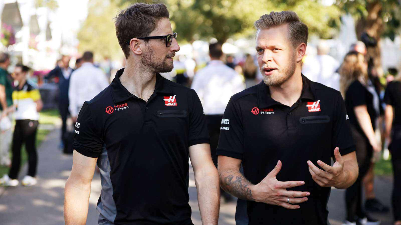Kevin Magnussen and Romain Grosjean deep in conversation at a racing event Wallpaper