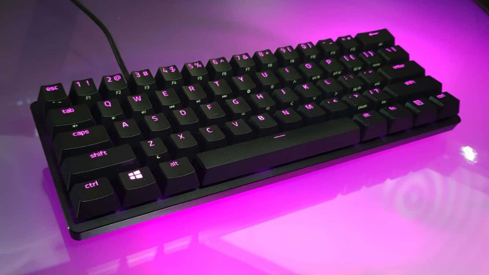 A Black Keyboard With Pink Lights On It