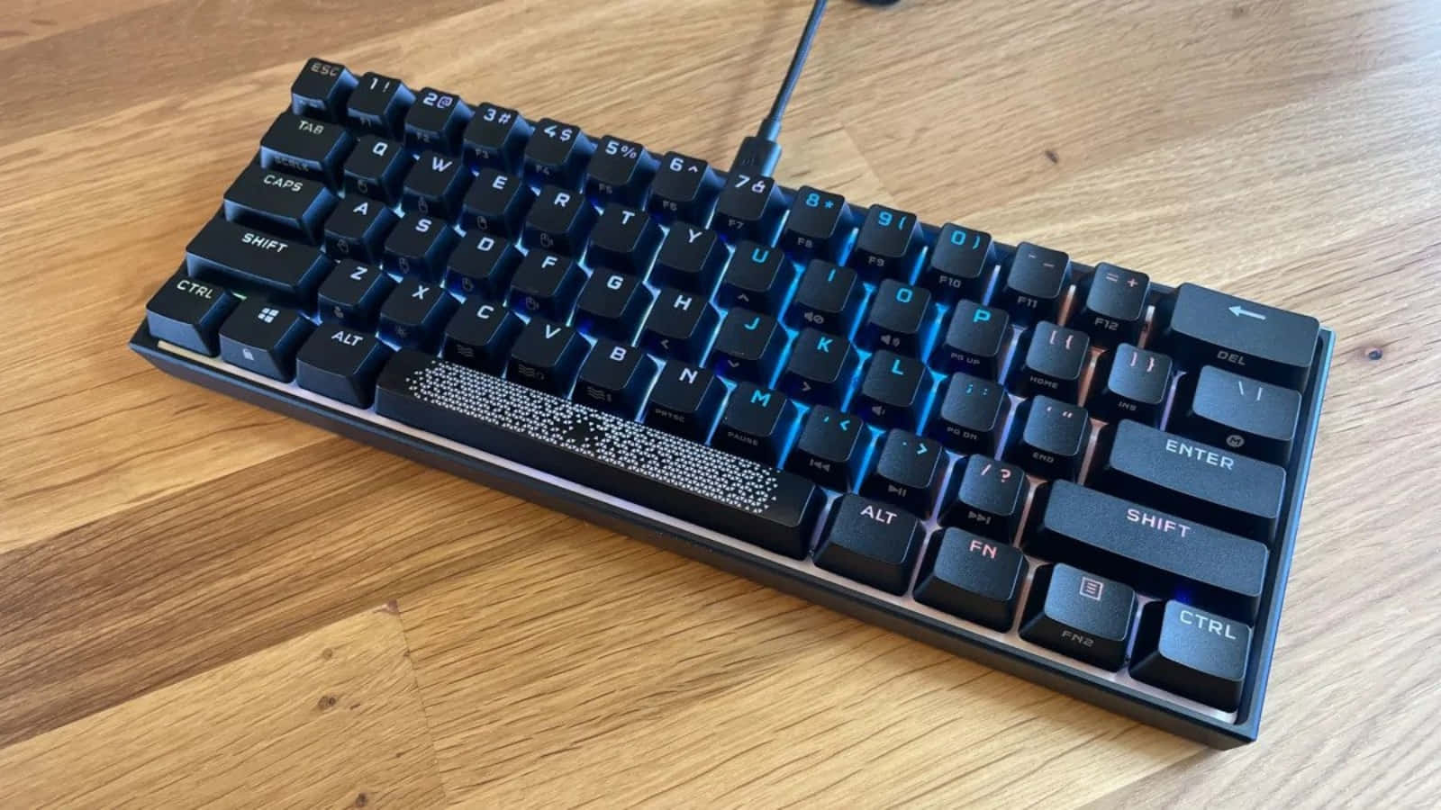 A Black And Blue Keyboard On A Wooden Table