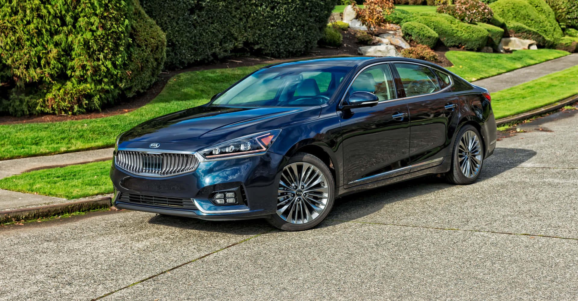 Sleek silver Kia Cadenza cruising on an open road Wallpaper