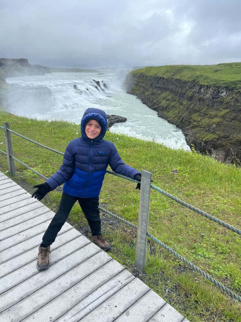 Criançavisitando A Cachoeira Gullfoss No Sudoeste Da Islândia. Papel de Parede