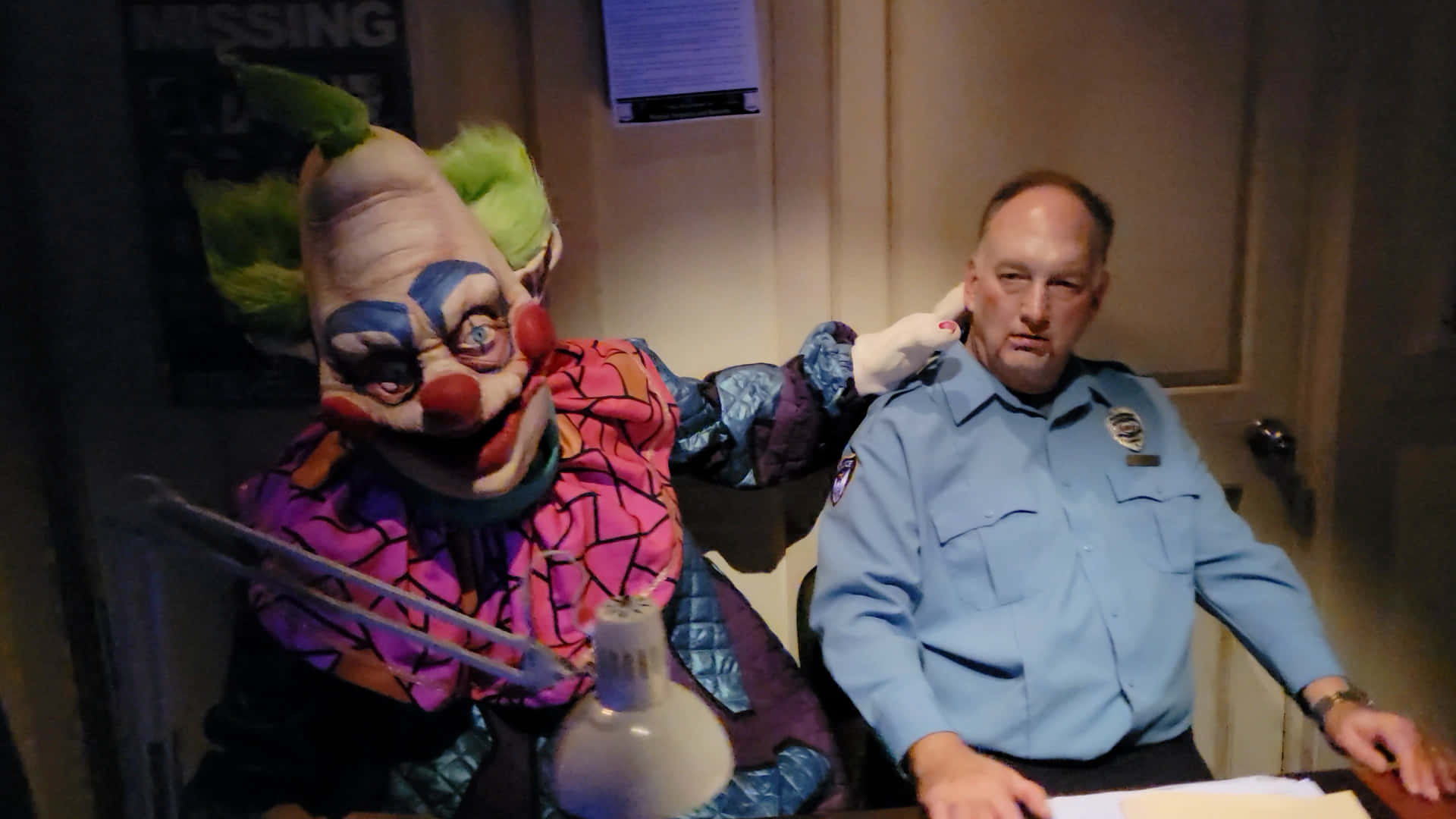 A Clown Dressed As A Police Officer Sits Next To A Desk Wallpaper