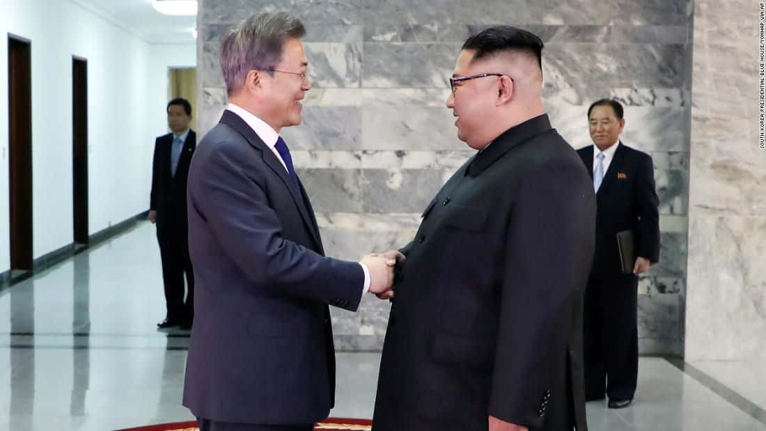 Two Men Shaking Hands In A Room