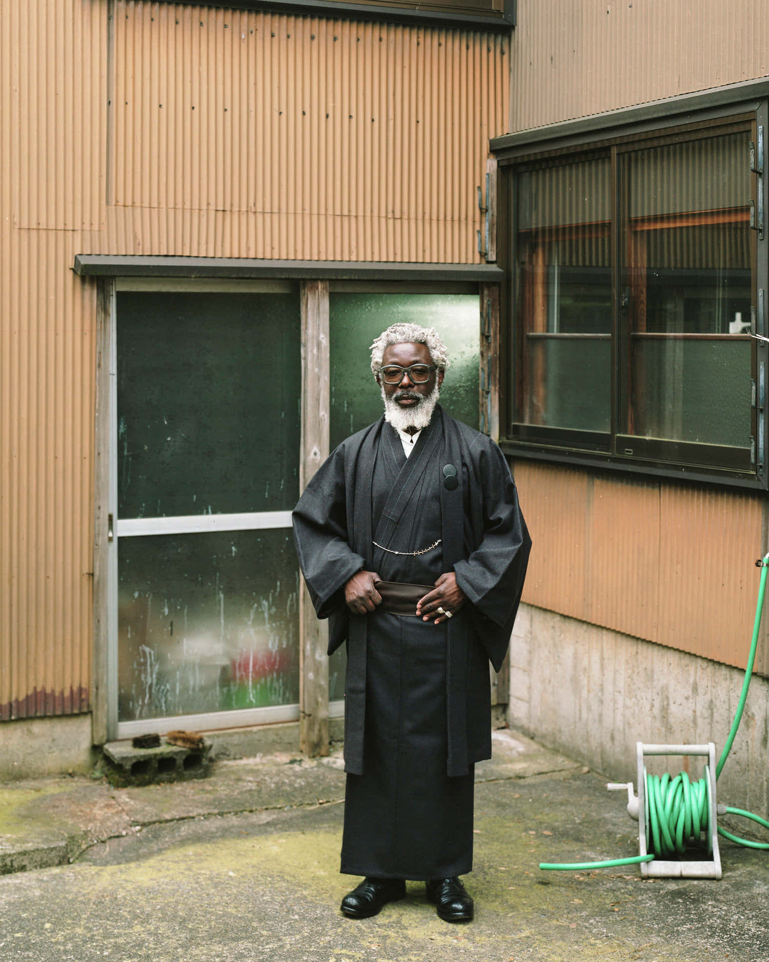 A Man In A Black Robe Standing Outside