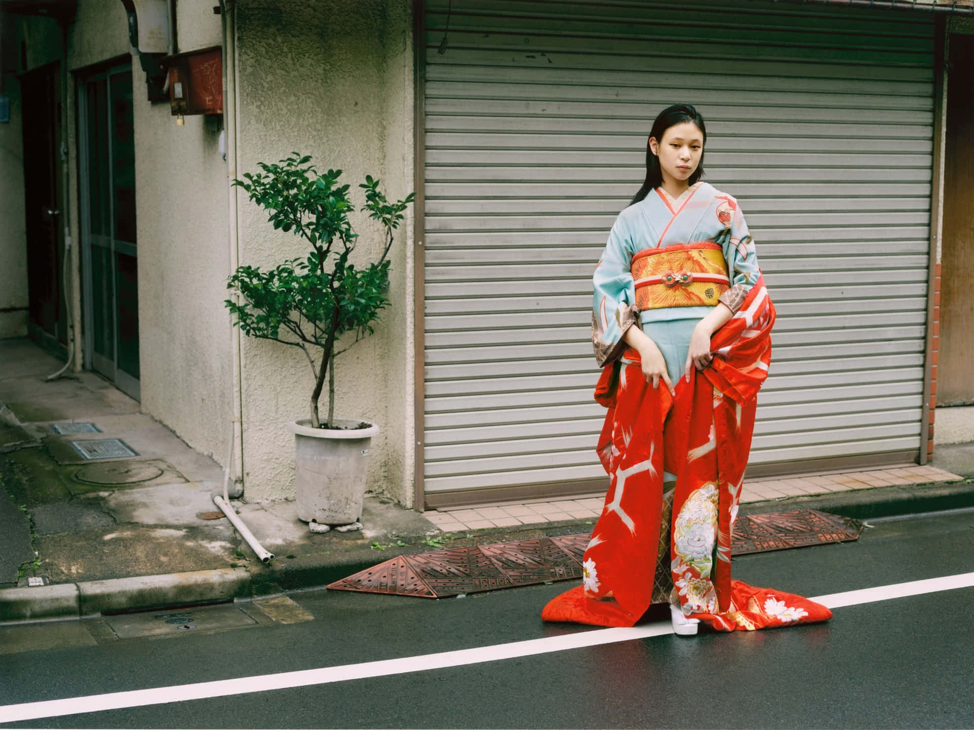 A Woman In A Red Kimono Standing On The Street