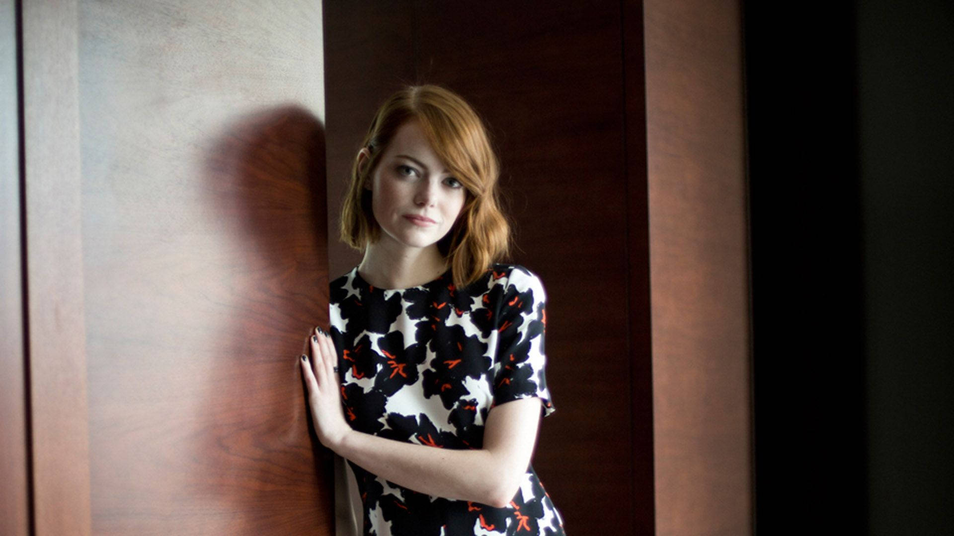 Emma Stone smiles confidently in a stunning portrait. Wallpaper