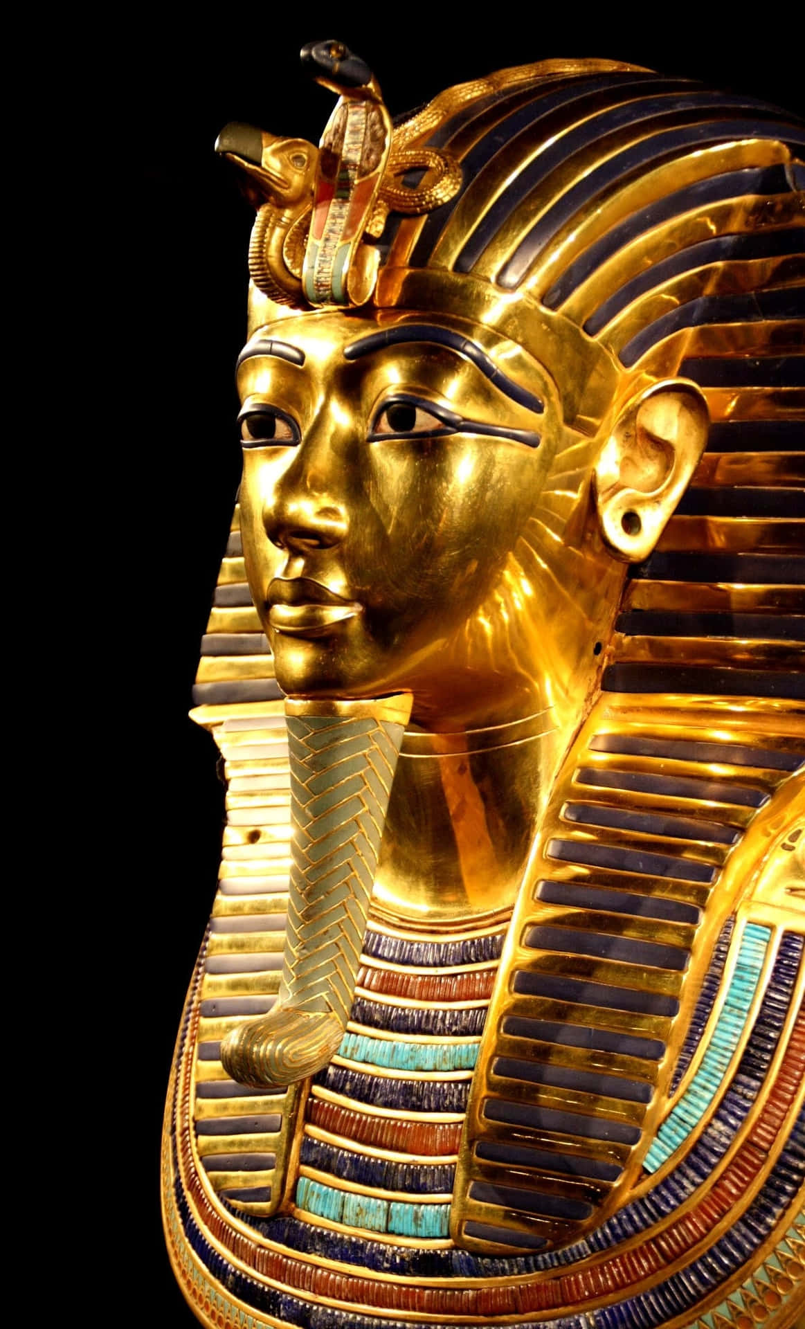 A Golden Egyptian Mask Is Shown On A Black Background