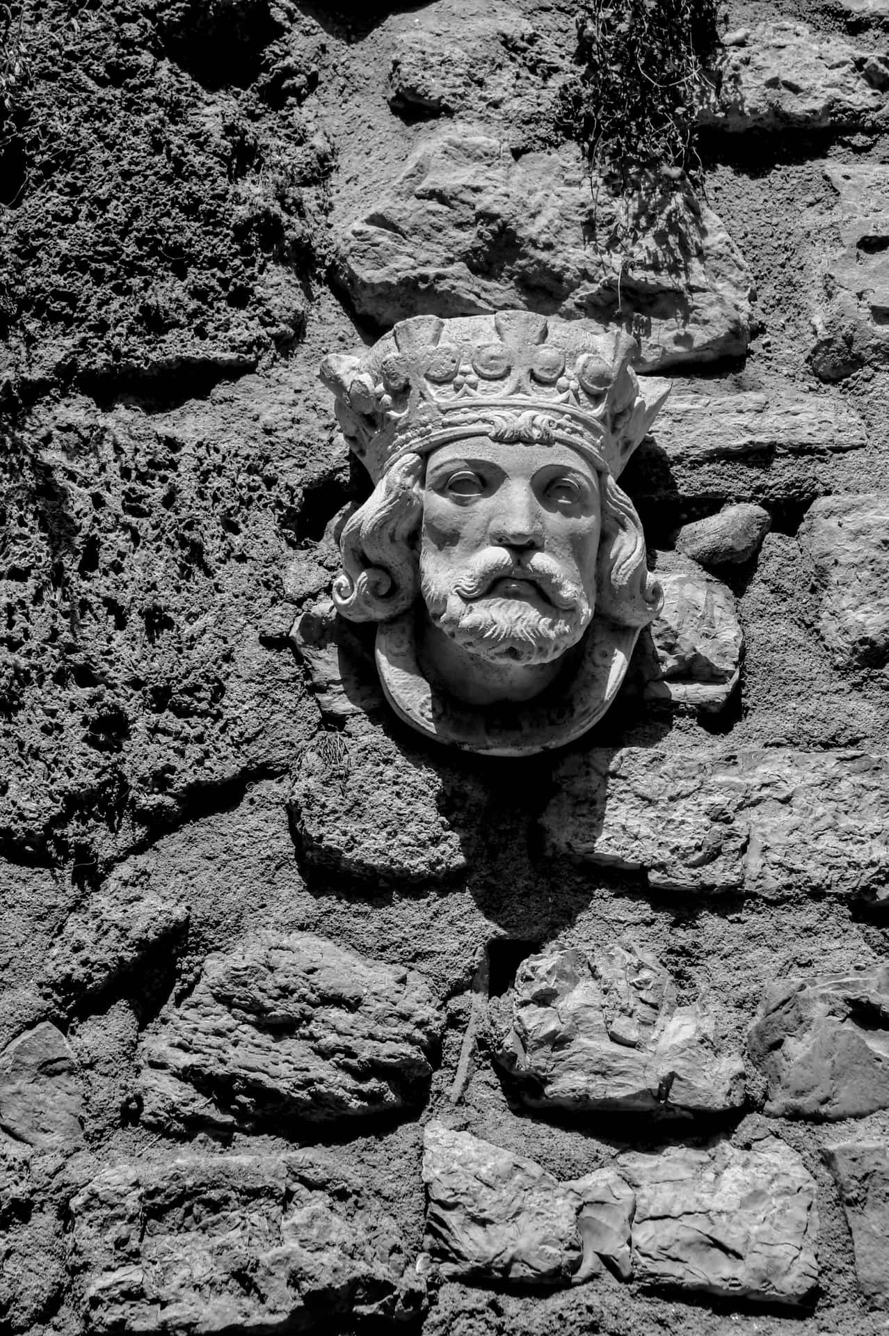 Einschwarzweißfoto Einer Steinmauer Mit Dem Kopf Eines Königs.
