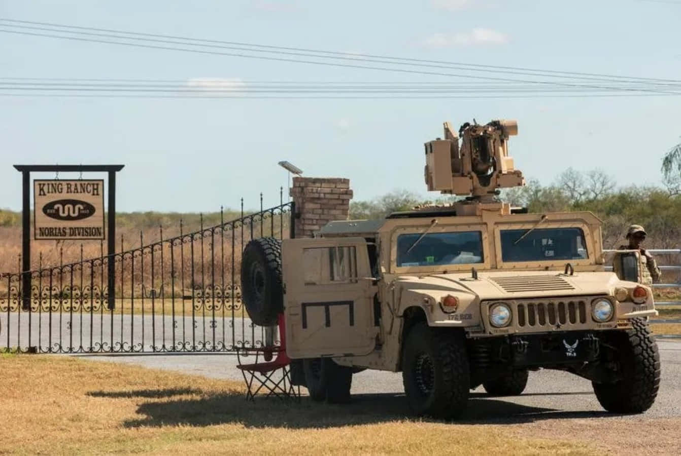 A Military Vehicle Is Parked In Front Of A Gate