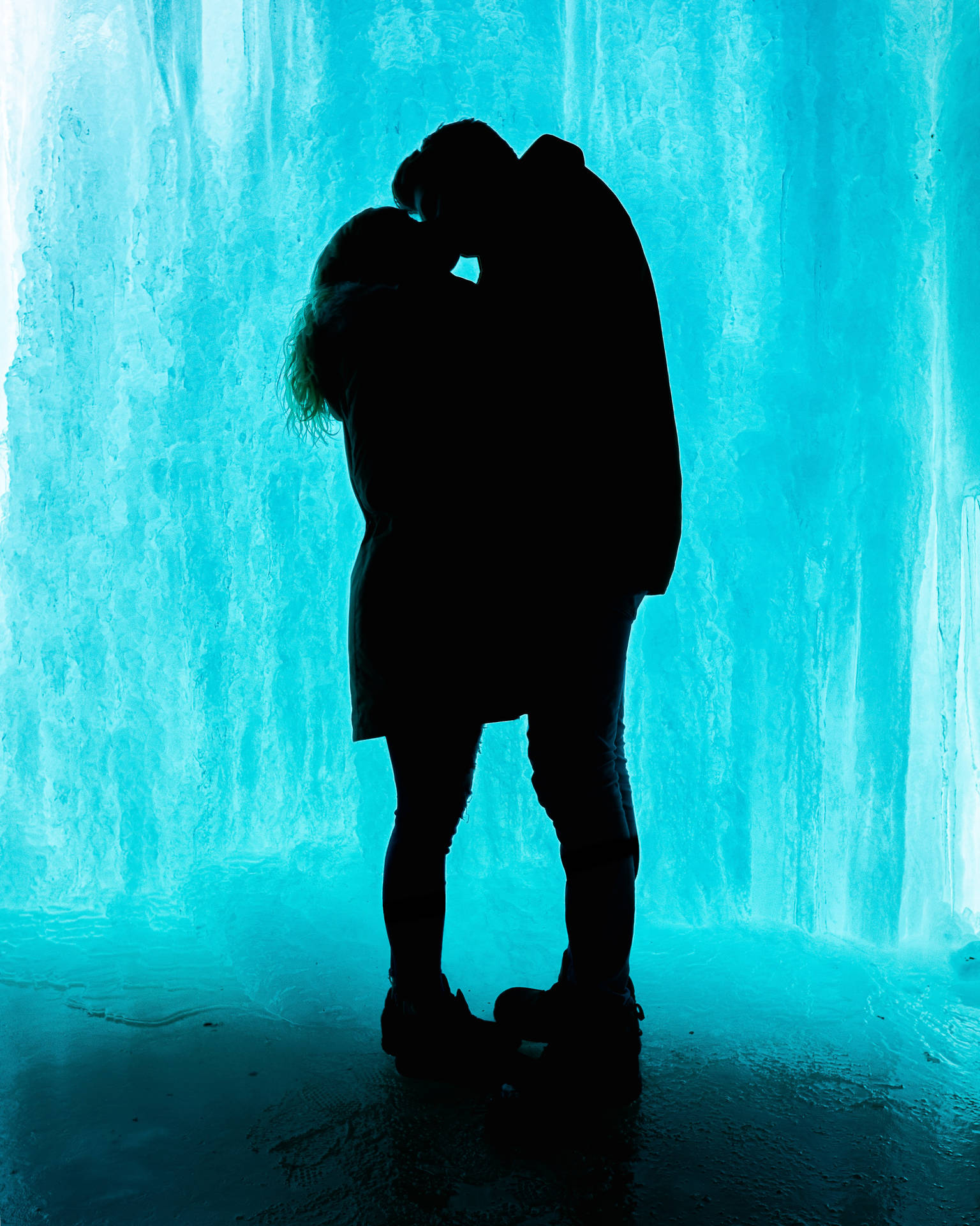 Two silhouetted lovers wrapped in a passionate embrace. Wallpaper