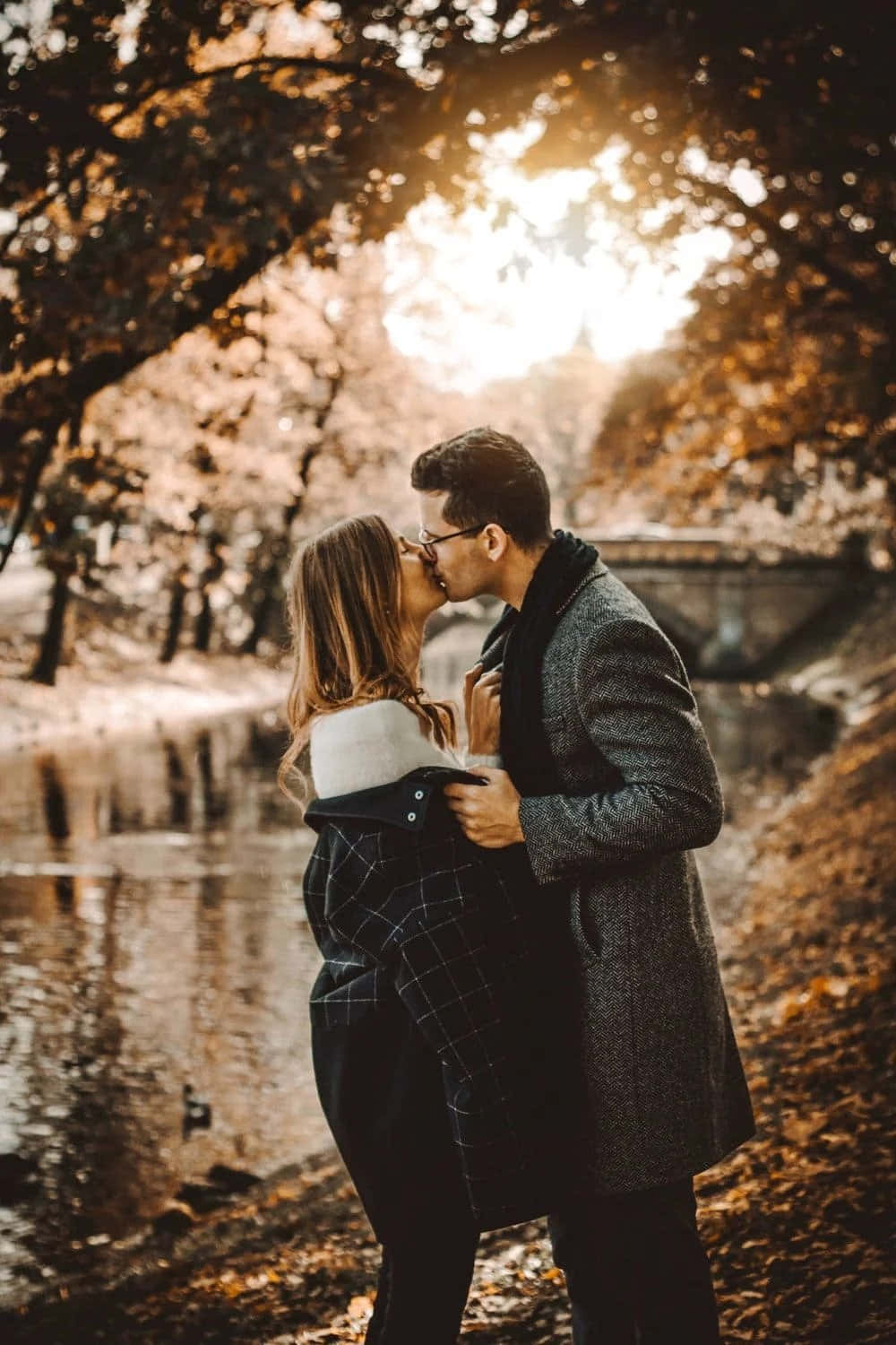 Couple Kissing By The River During Their Engagement Session