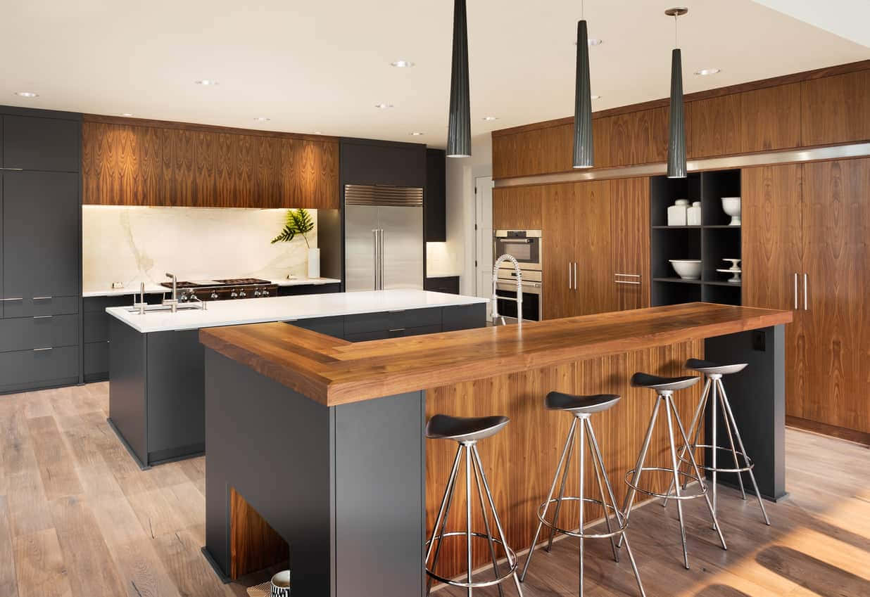 A Modern Kitchen With Wooden Cabinets And Stools
