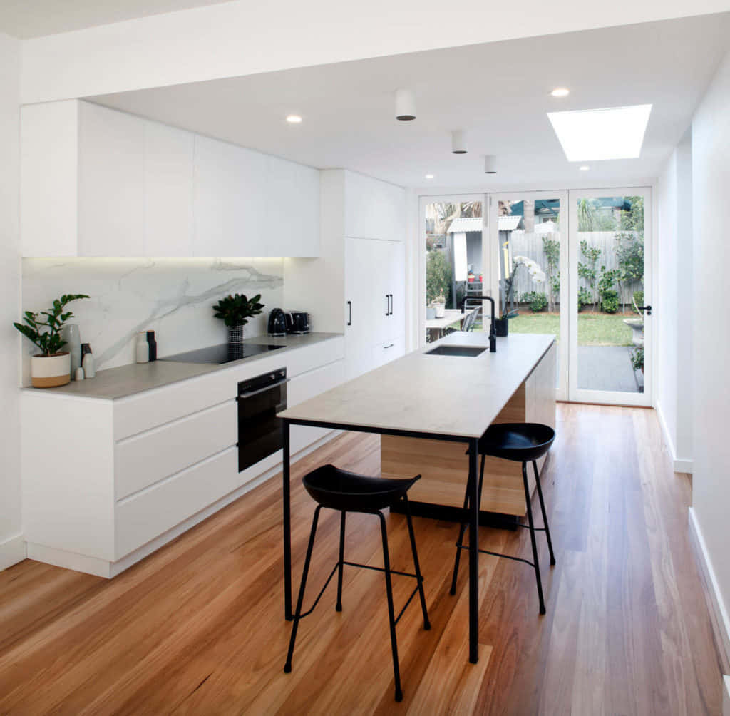 A Modern Kitchen With Wooden Floors And White Walls