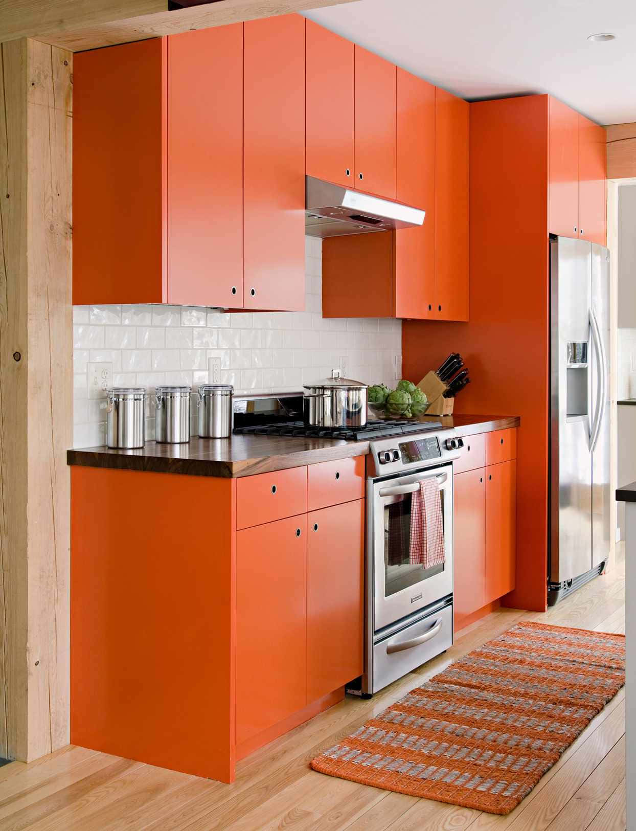 Eineküche Mit Orangefarbenen Schränken.