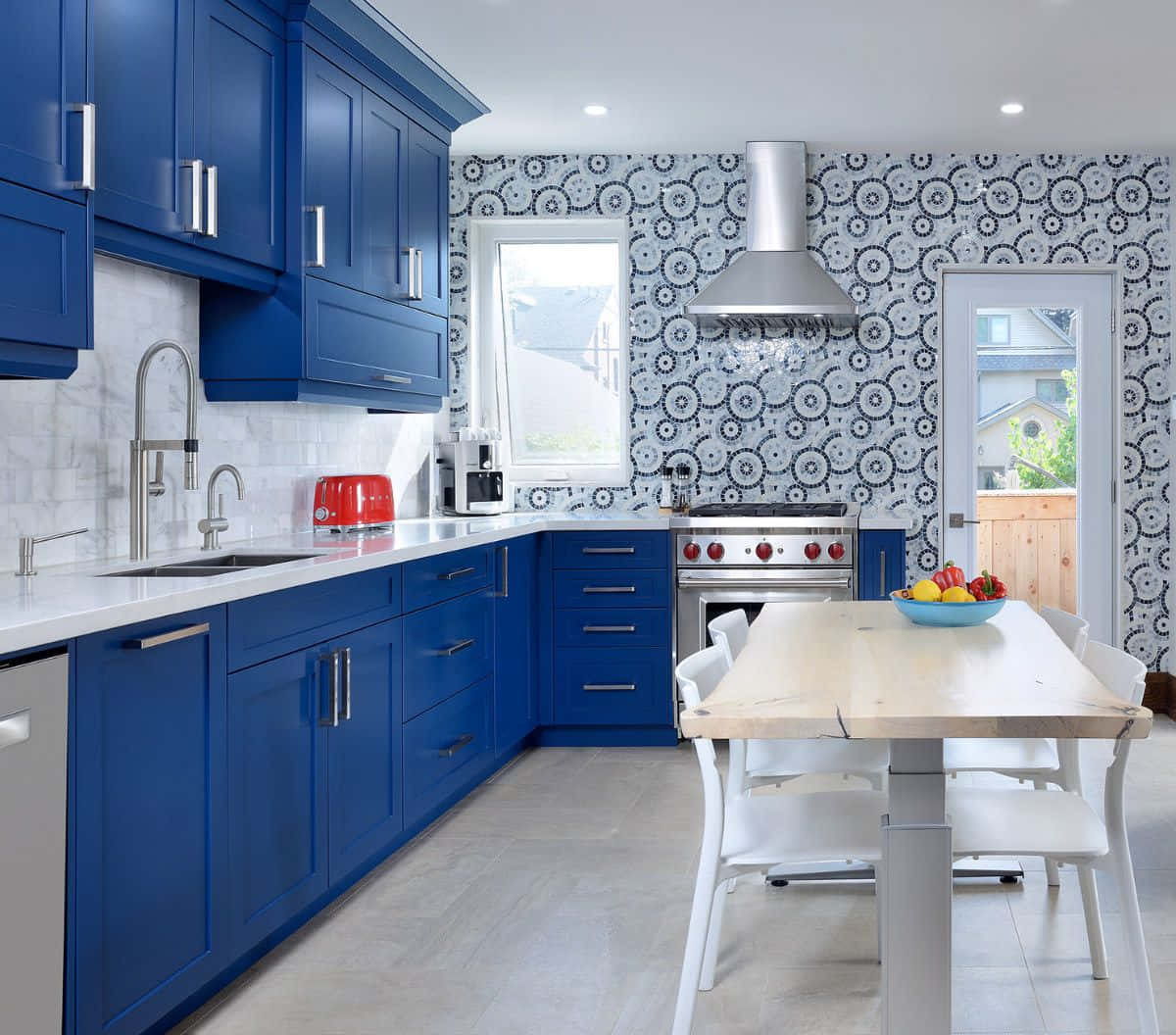 A Blue Kitchen With White Cabinets And A Table