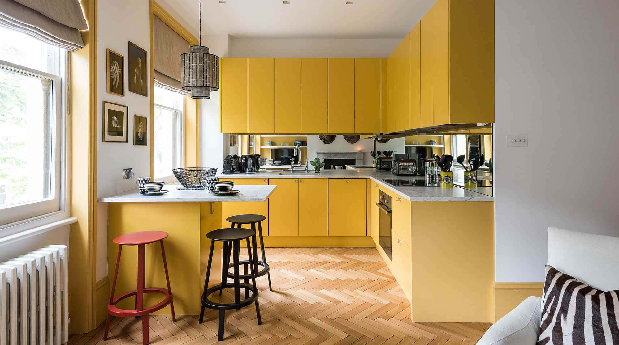 A Yellow Kitchen With Wooden Floors And Stools