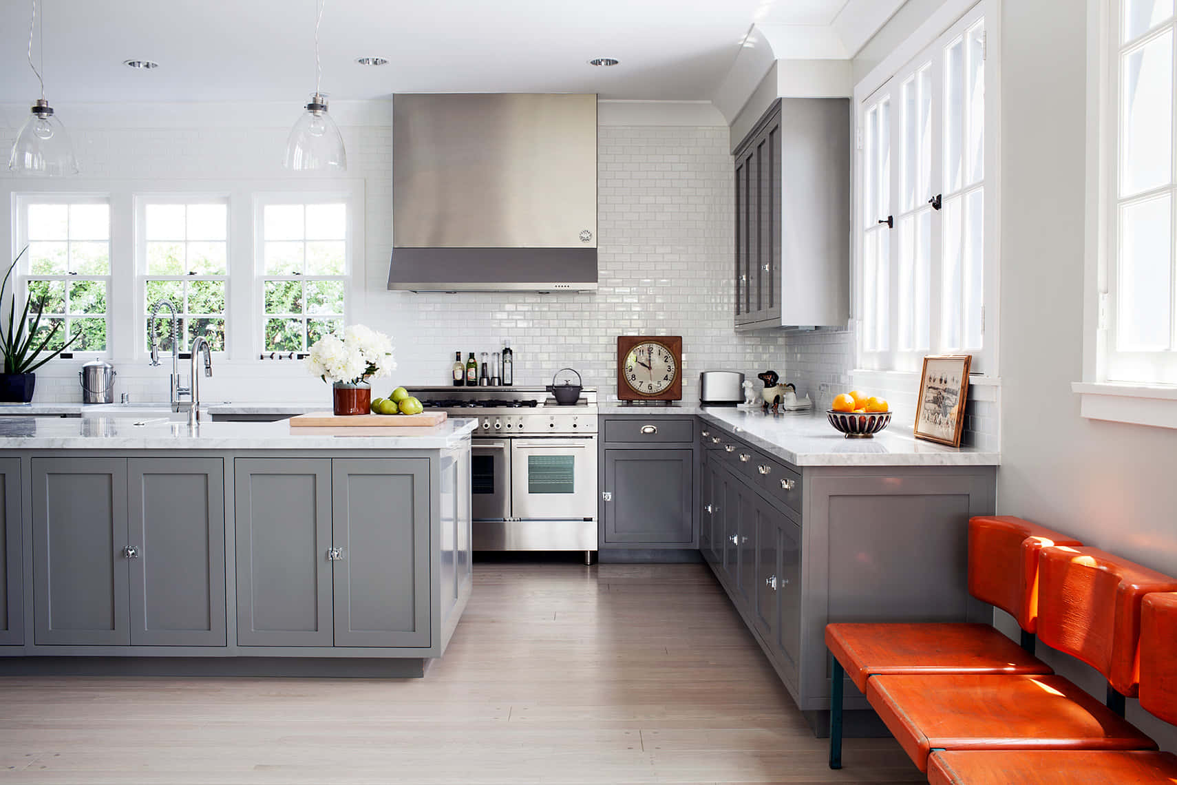 A Kitchen With A White Island And Gray Cabinets