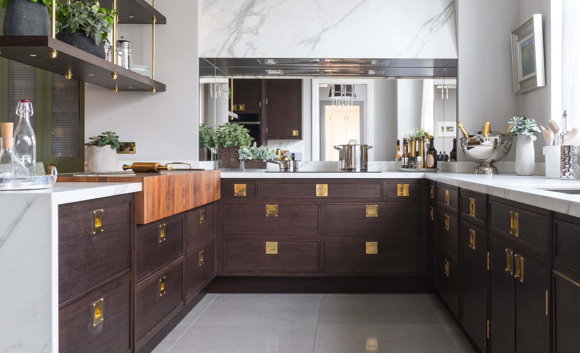 A Kitchen With A Marble Counter Top And Wooden Cabinets