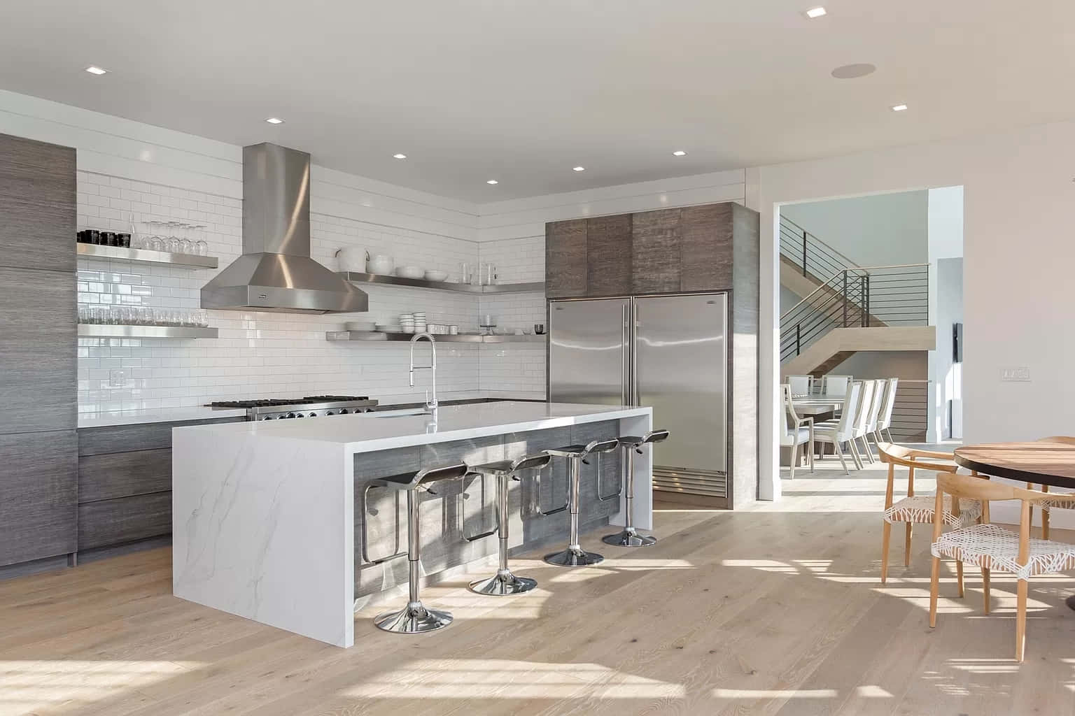 A Modern Kitchen With Wood Floors And A Wooden Island