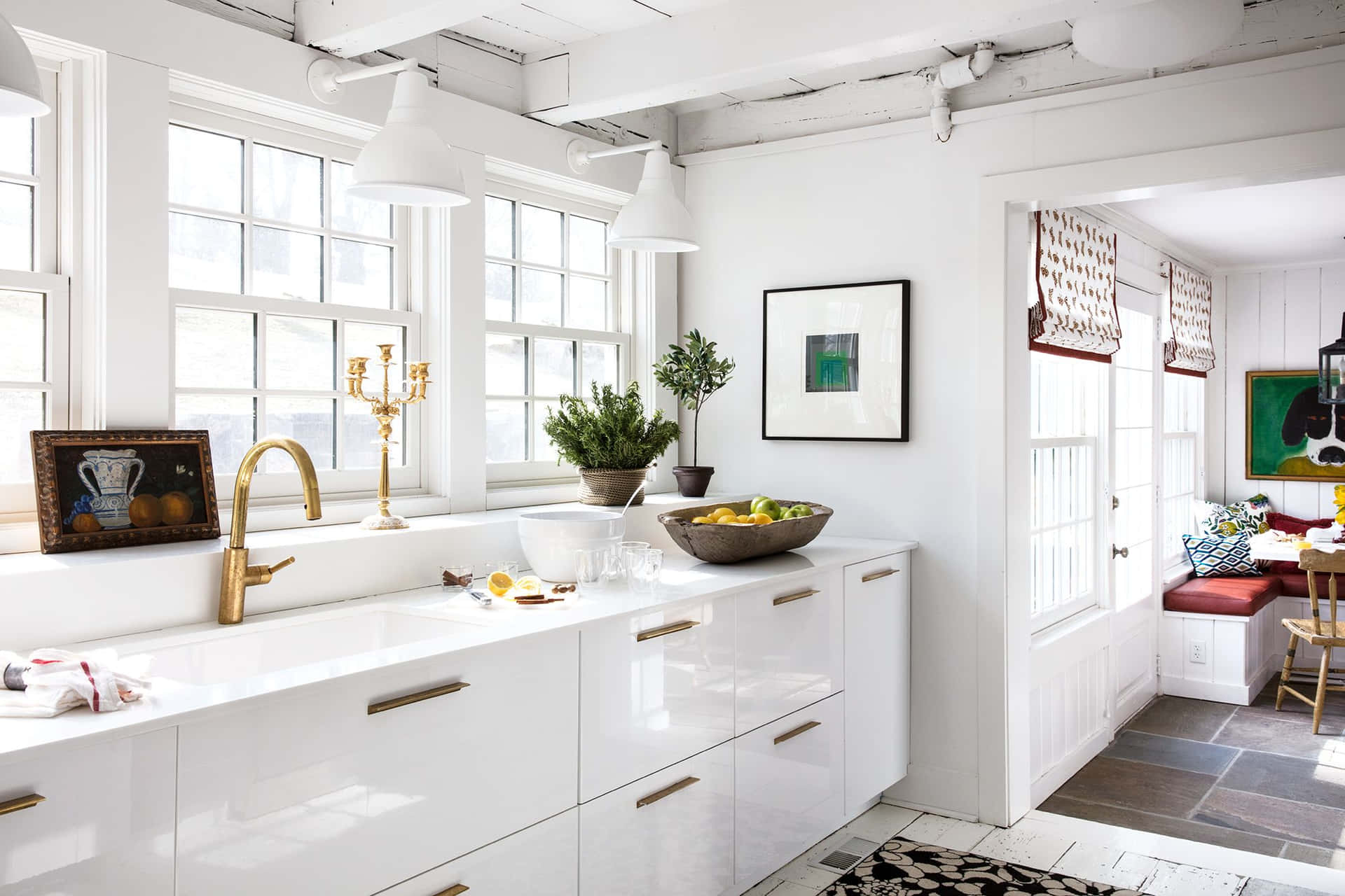 A White Kitchen With A Gold Sink And A Rug
