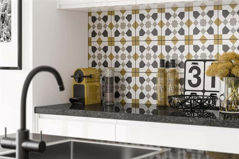 A Kitchen With A Black And Gold Tiled Backsplash