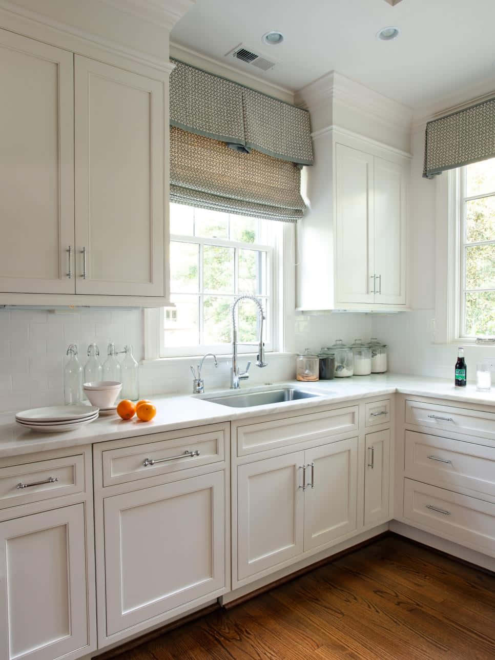A White Kitchen With A Sink And Counter Top