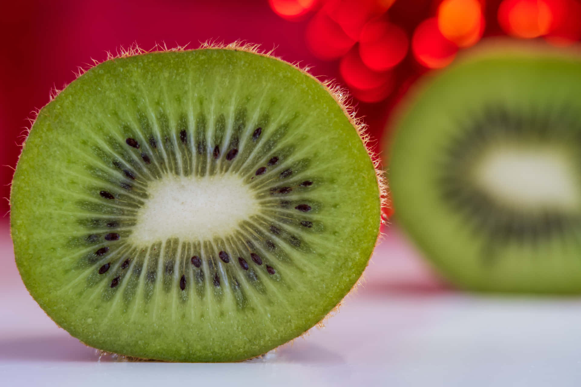 A close-up view of a sliced kiwi fruit on a wooden table