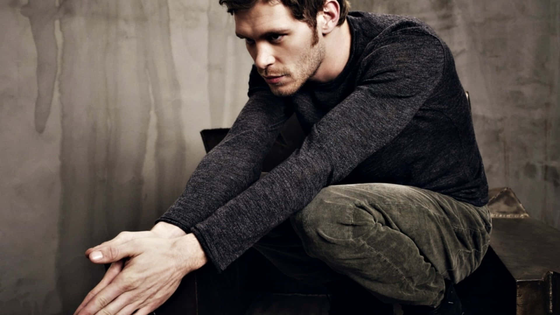 Klaus Mikaelson Crouching On Chair Wallpaper