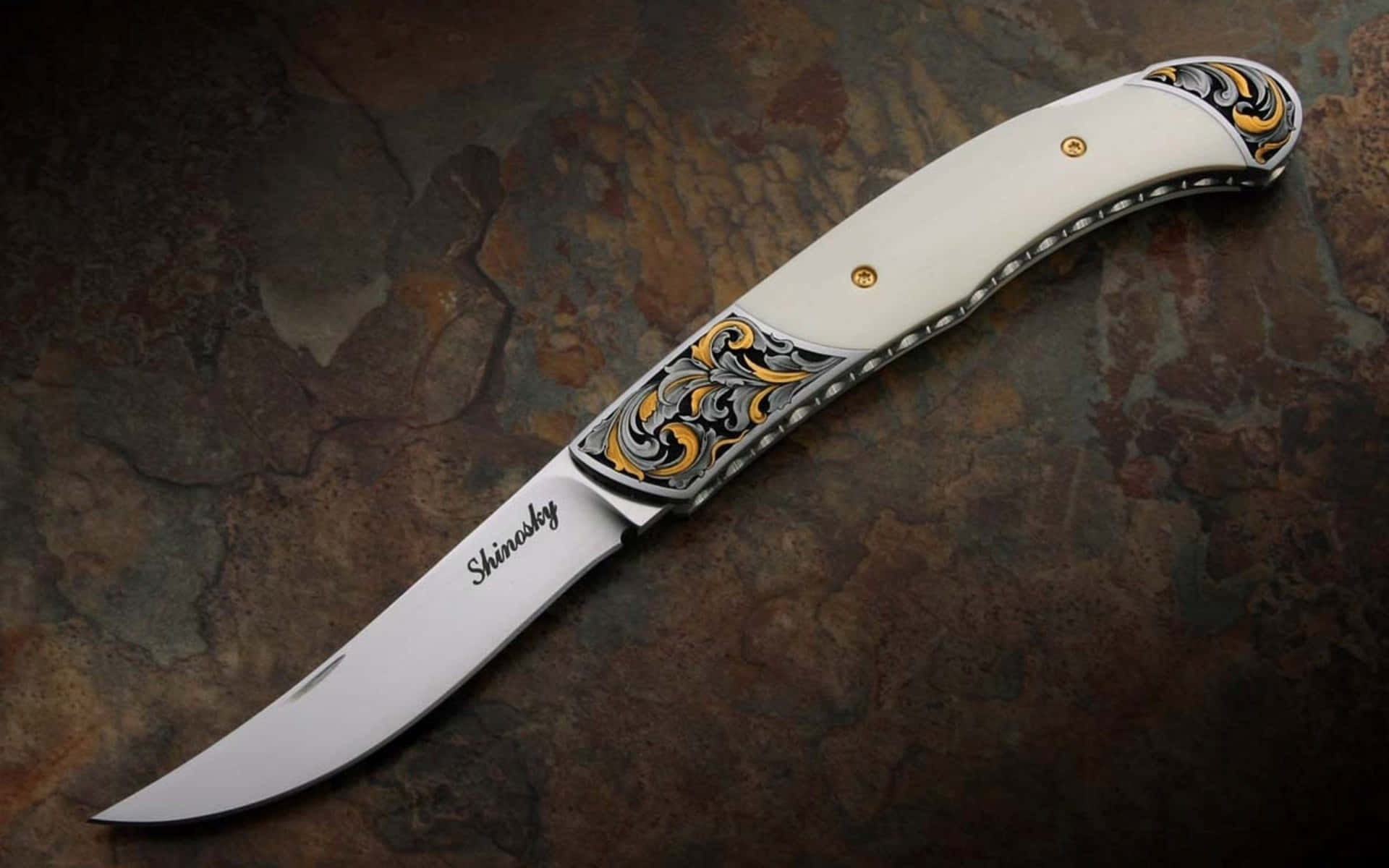 A Knife With A White Handle And Gold Accents