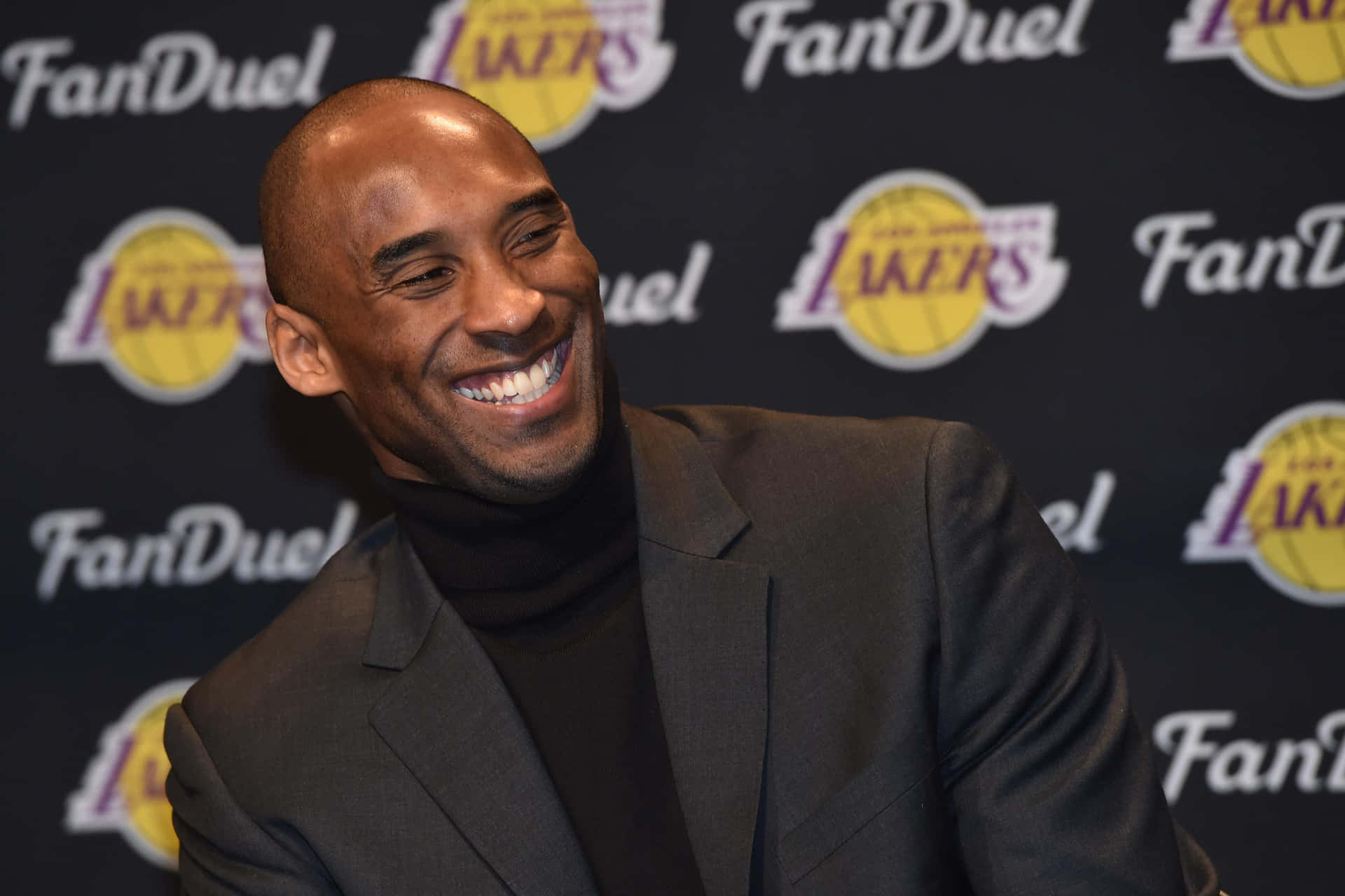 Kobe Bryant Glimlachend Op Evenement Achtergrond