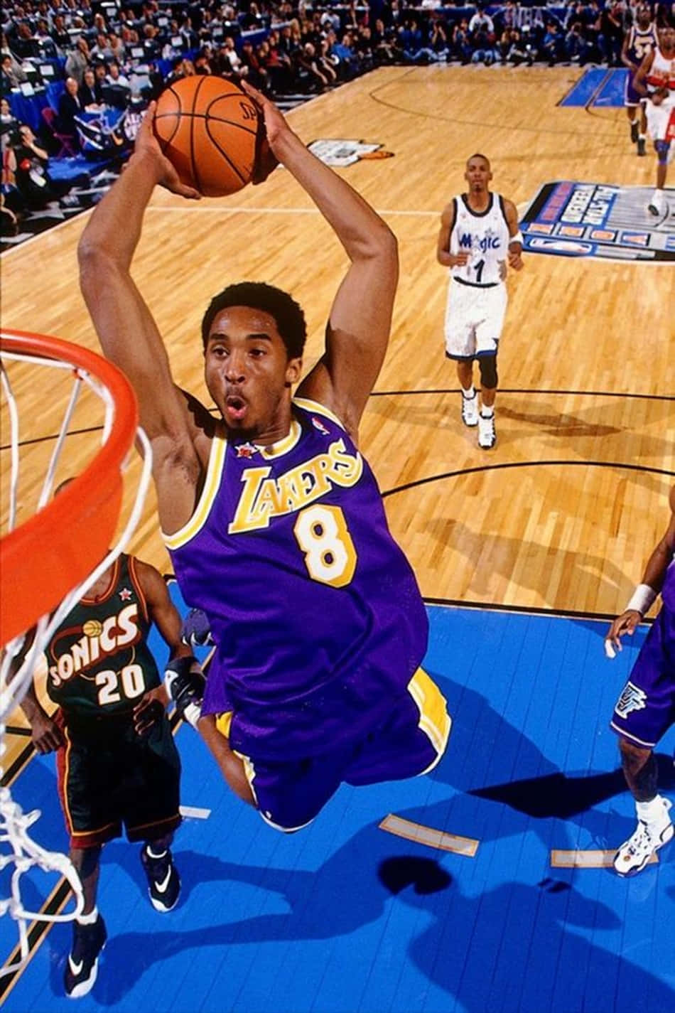 En basketballspiller er i luften, mens de banker bolden. Wallpaper