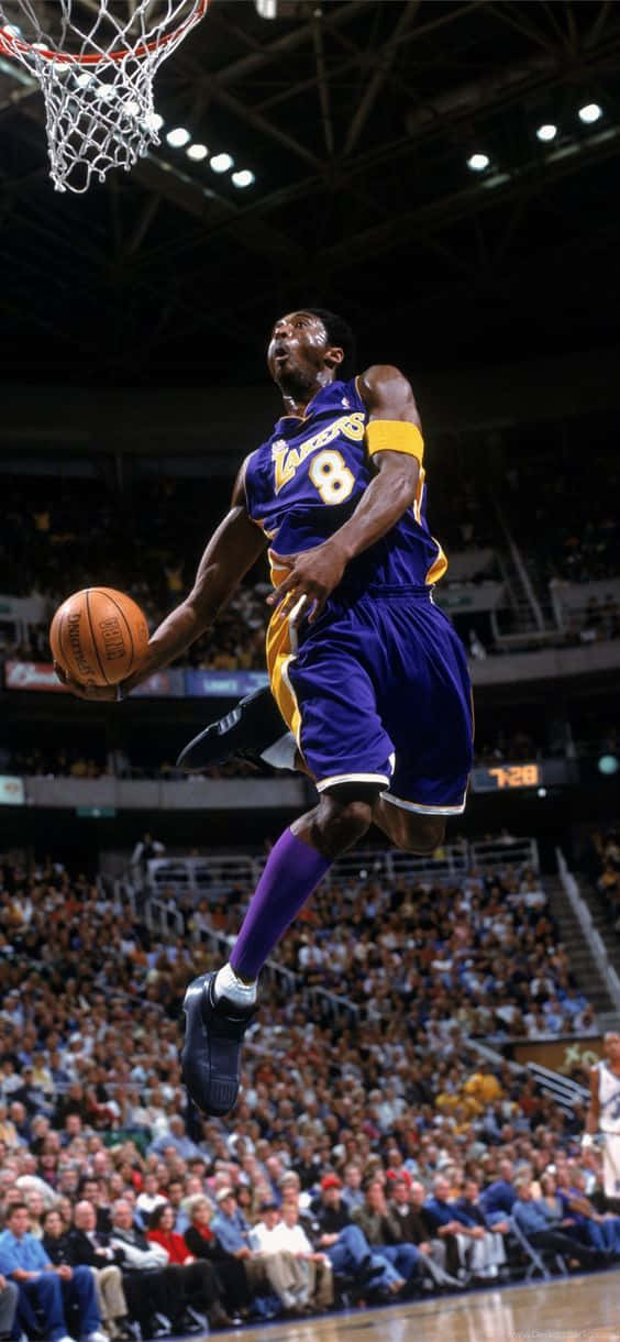 A Basketball Player In The Air Dunks The Ball Wallpaper