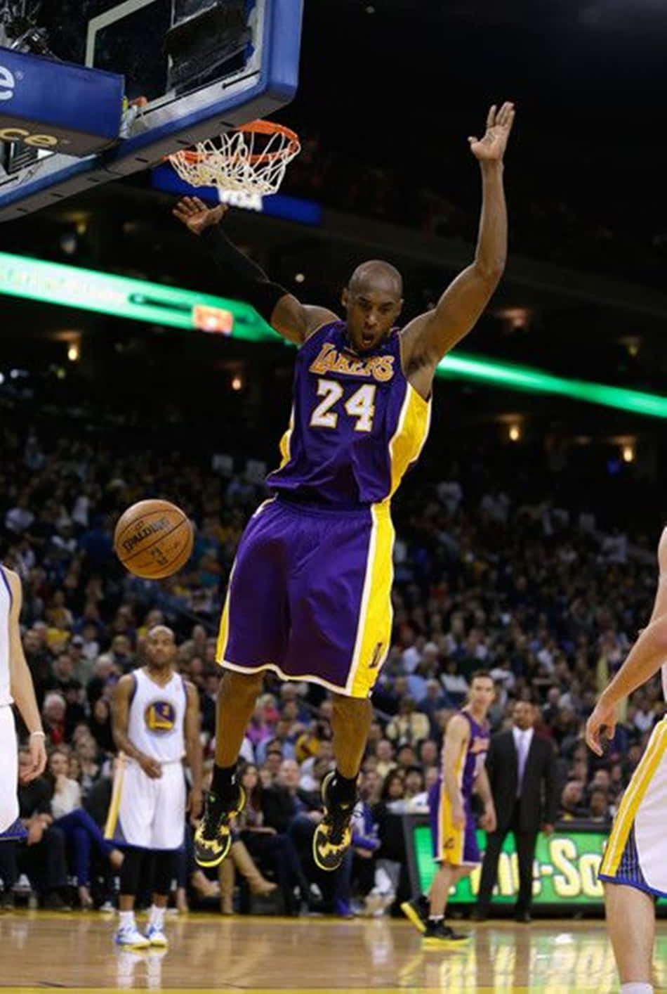 Kobe Bryant putting on an impressive performance as he soars through the air for an emphatic dunk. Wallpaper