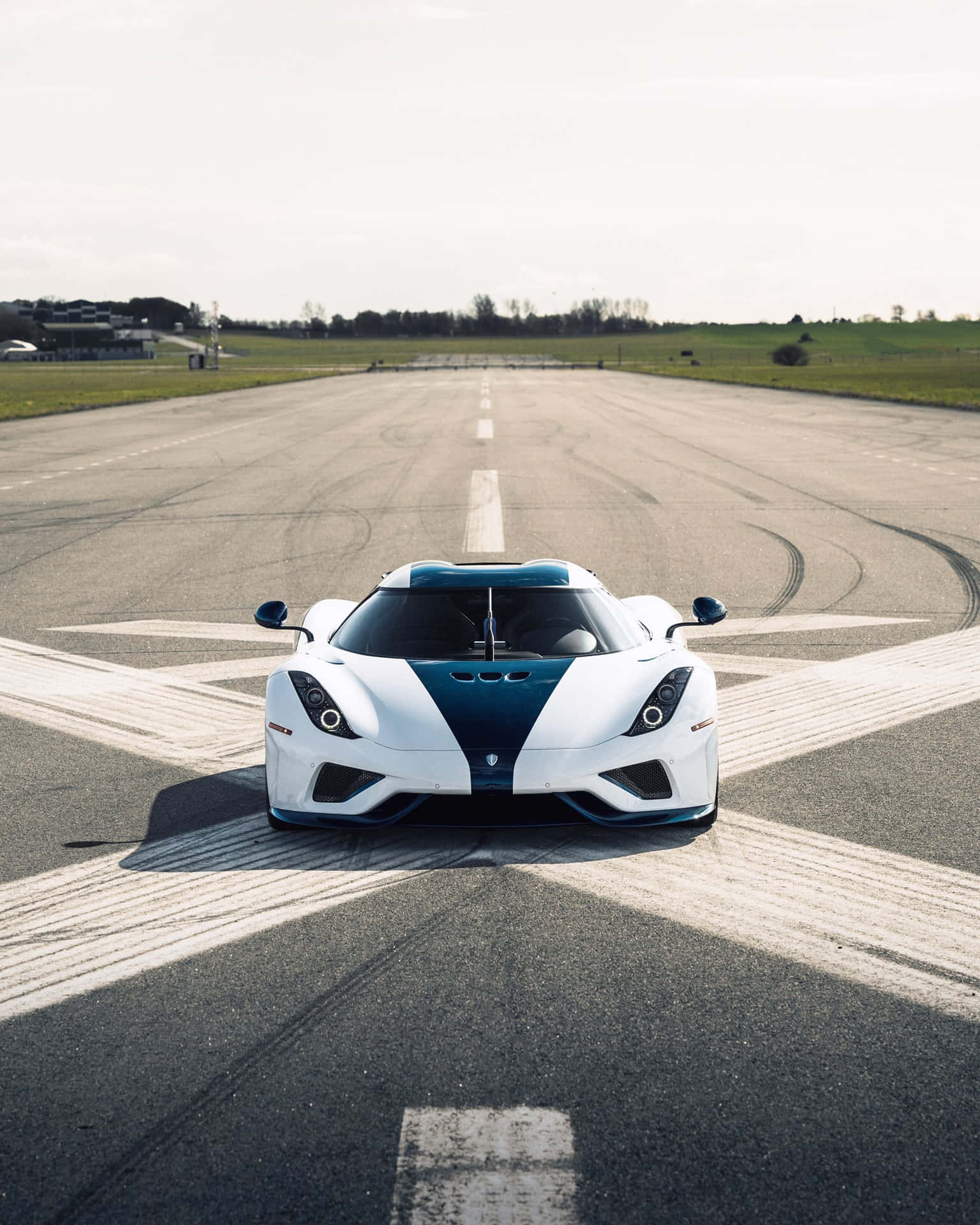 A White And Blue Sports Car On A Runway Wallpaper