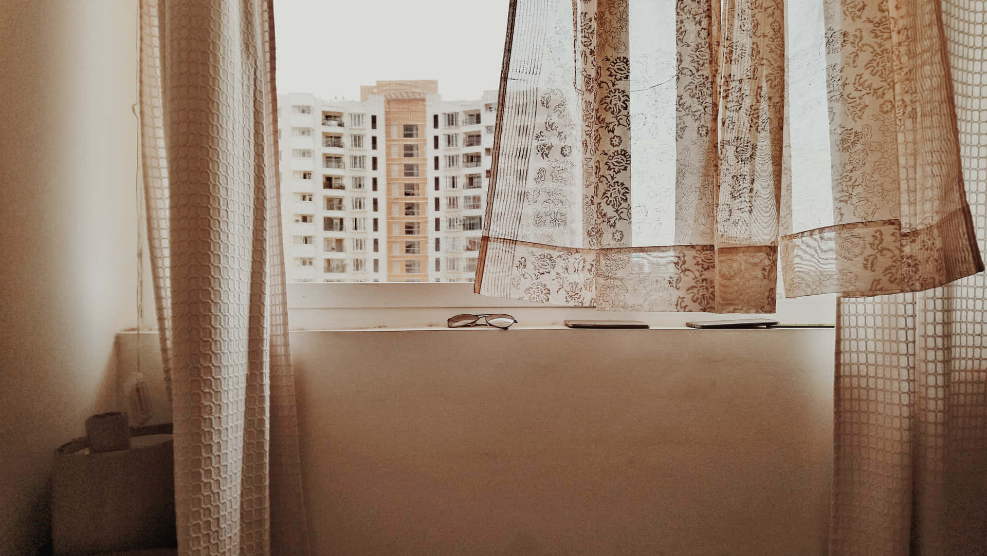 Et vindue med et stille blafrende gardin Wallpaper