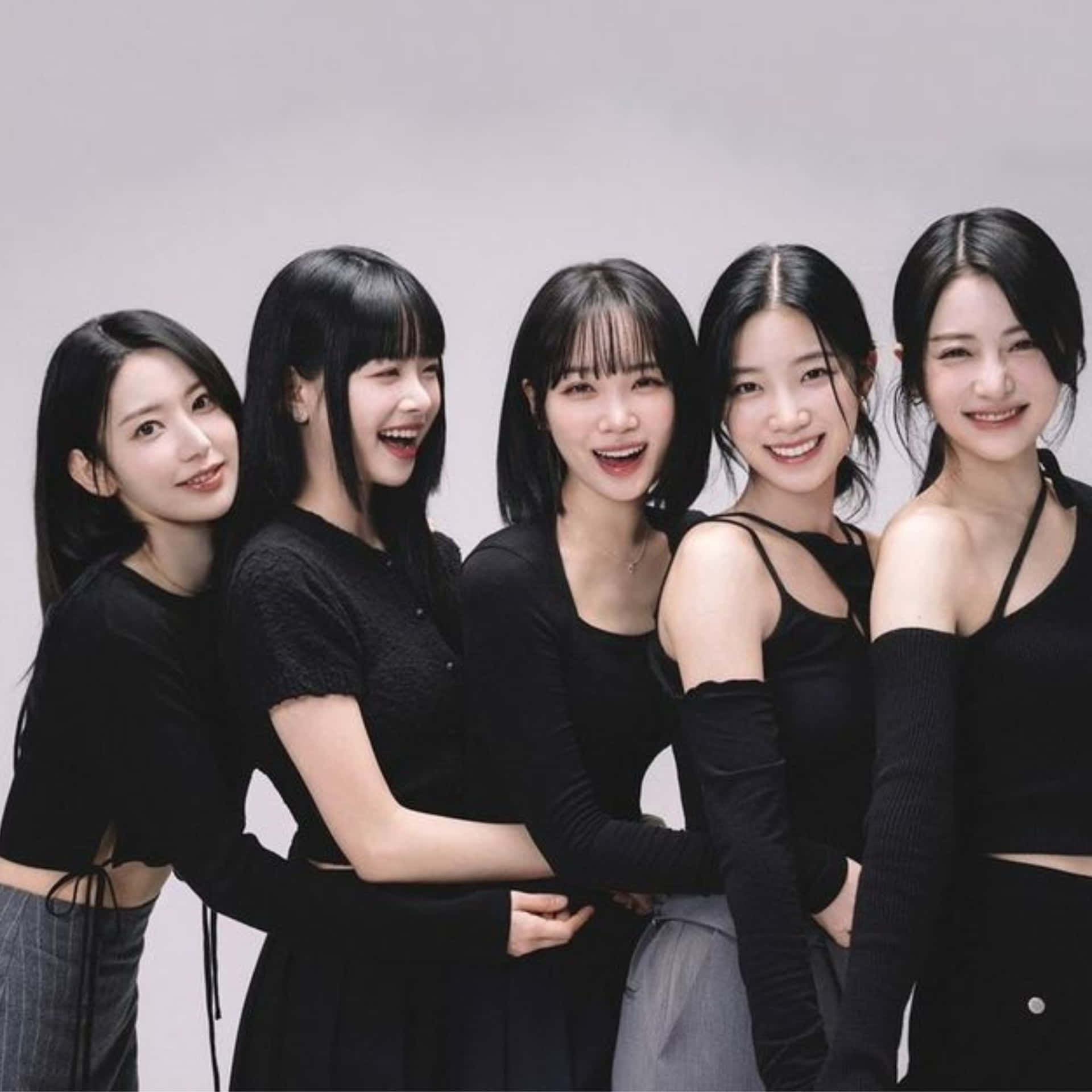 Kpop Group Smilingin Black Attire Wallpaper