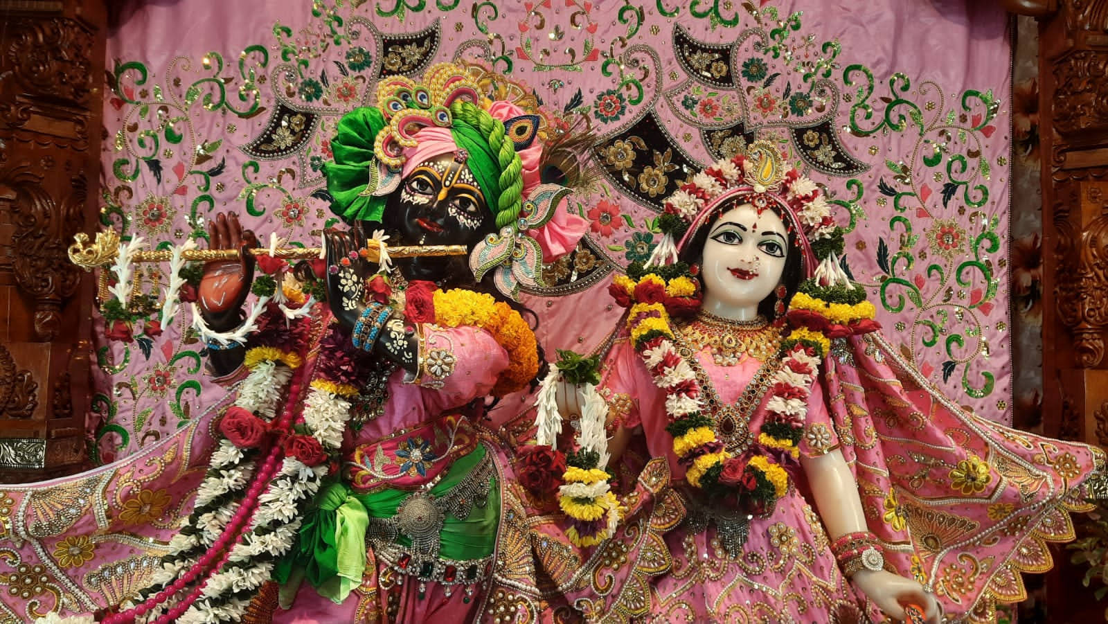 Krishna And Radha In Iskcon Temple Wearing Pink Wallpaper