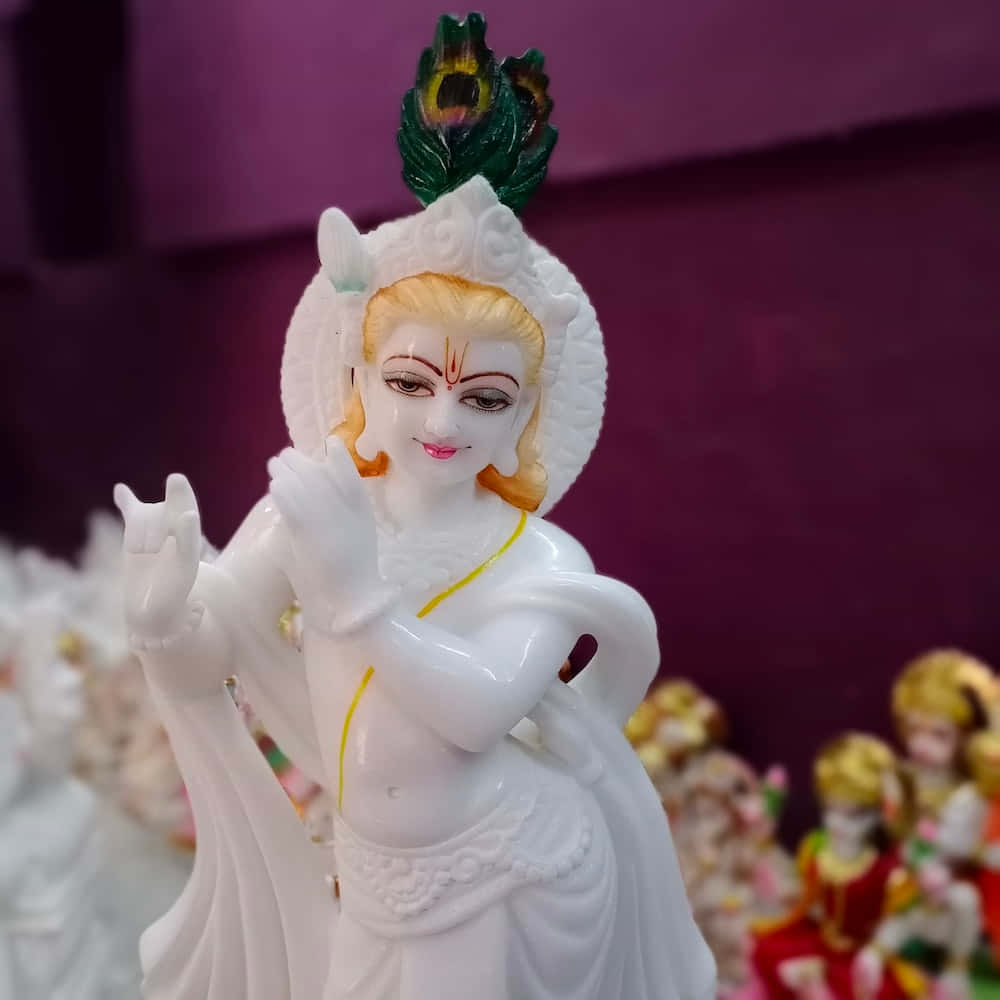 Unaestatua De Lord Krishna Con Una Pluma