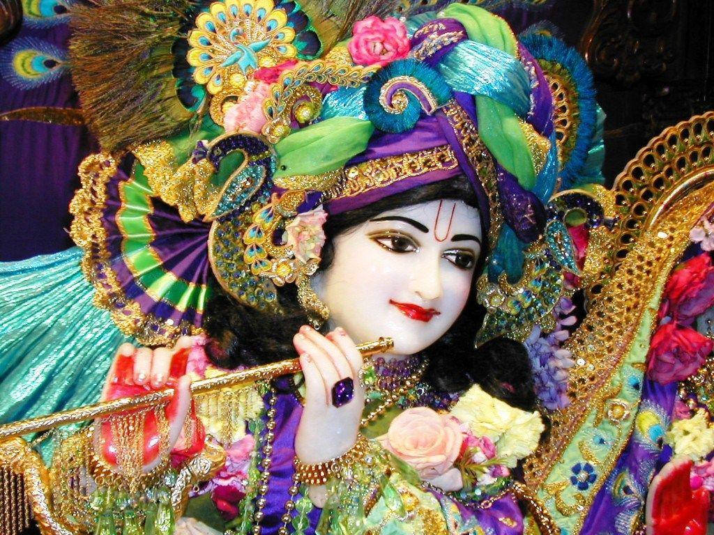 Krishna Ji med farverige klæder og helio strålende Wallpaper