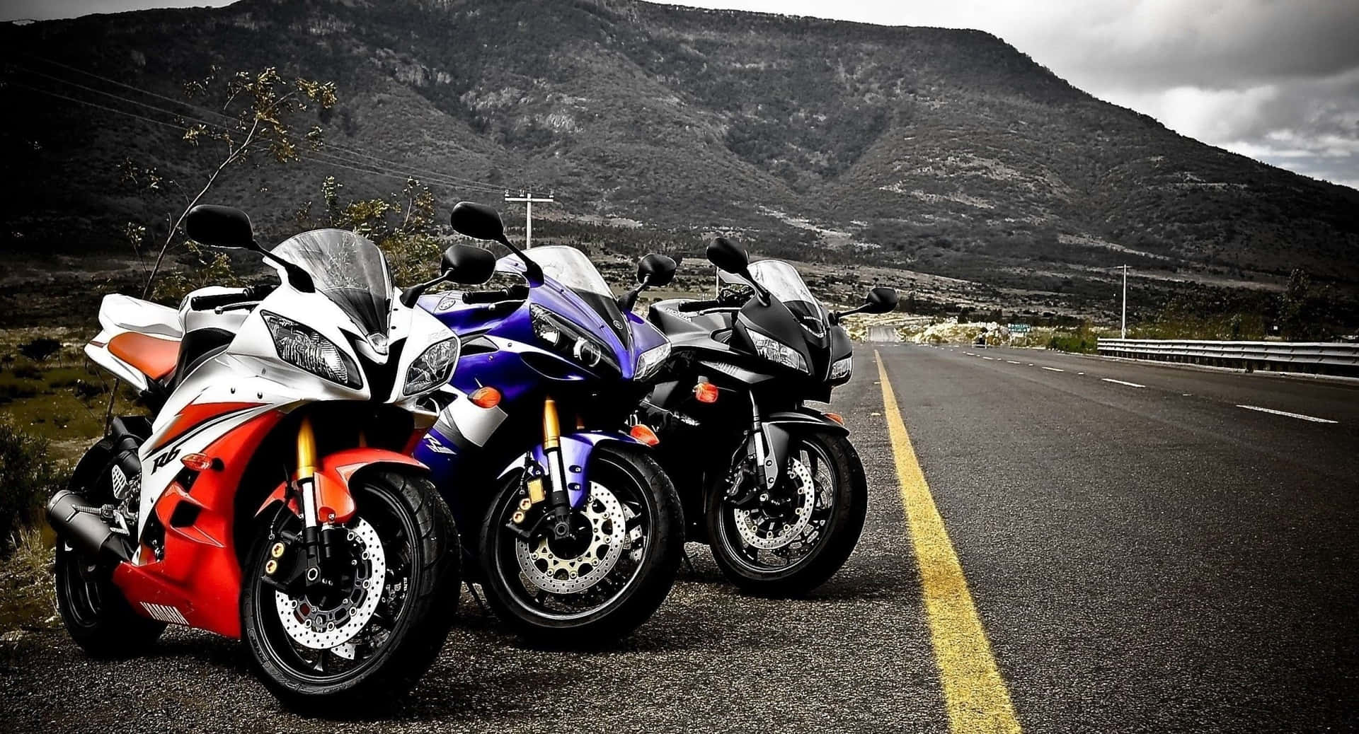 Three Motorcycles Parked On The Road