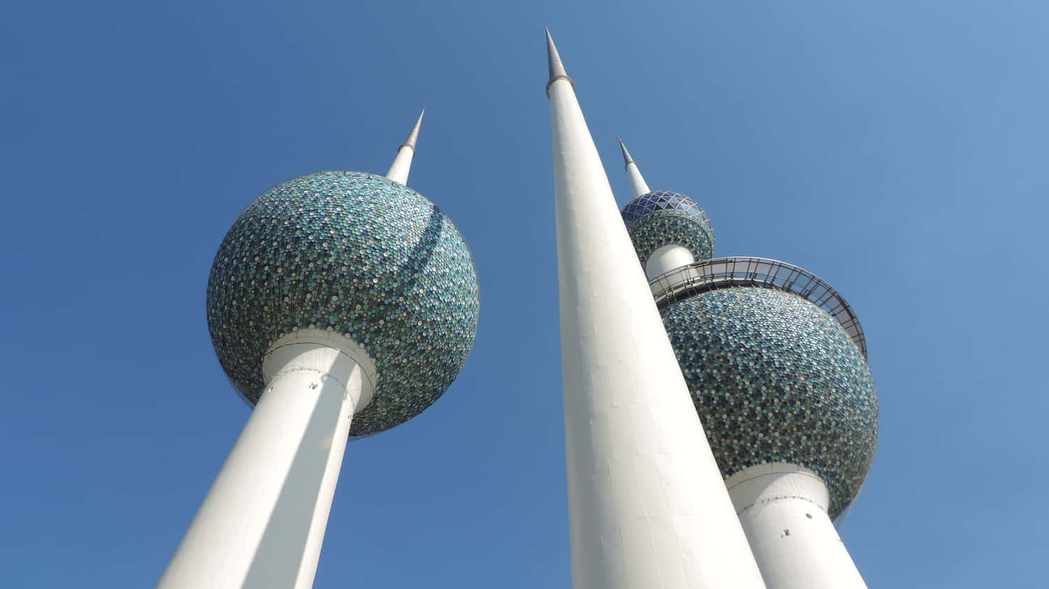 Caption: Landmark Kuwait Towers Standing Majestically Under A Clear Blue Sky Wallpaper