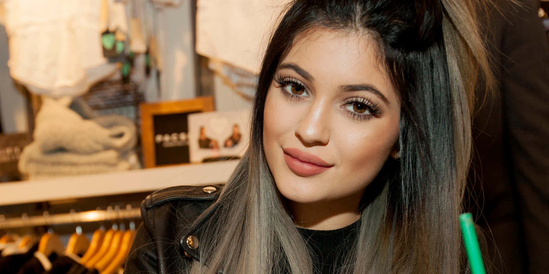 Kylie Jenner wearing a cropped black sweater, with bright pink hair and a full face of makeup. Wallpaper