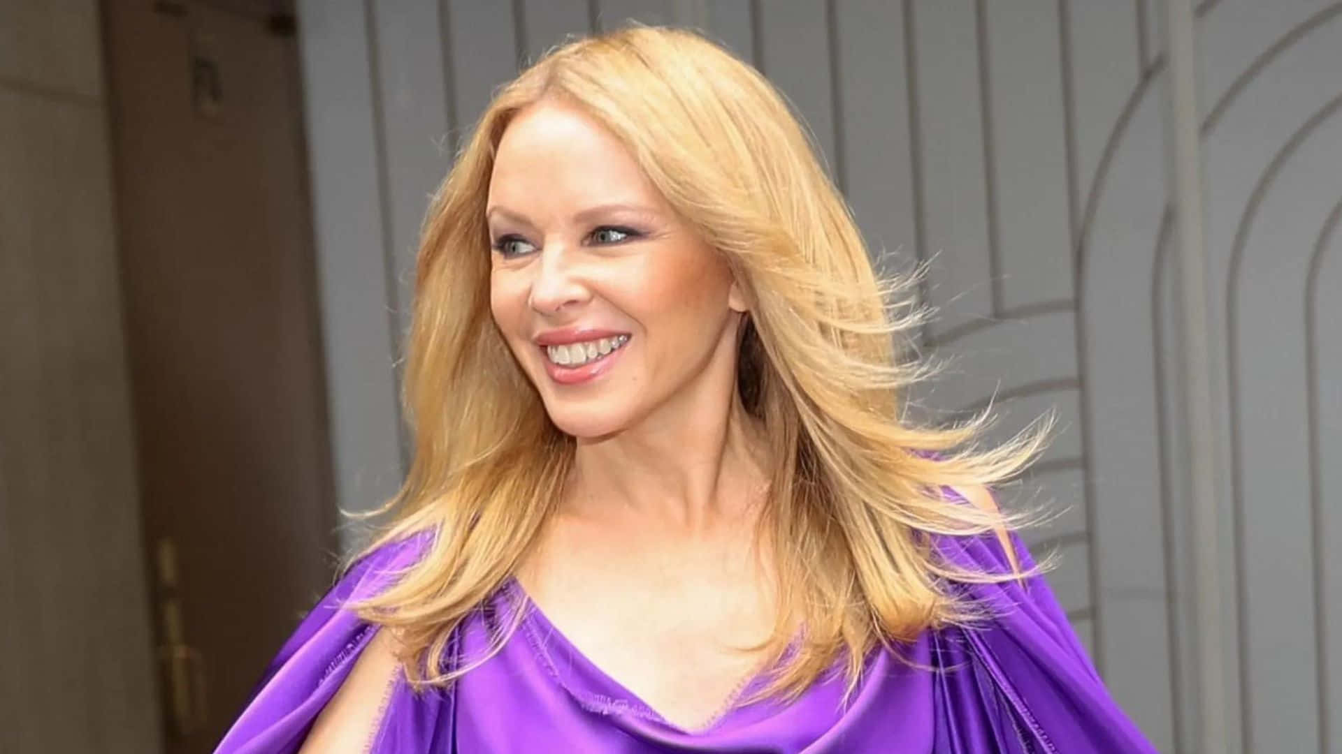 Kylie Minogue Smilingin Purple Dress Wallpaper