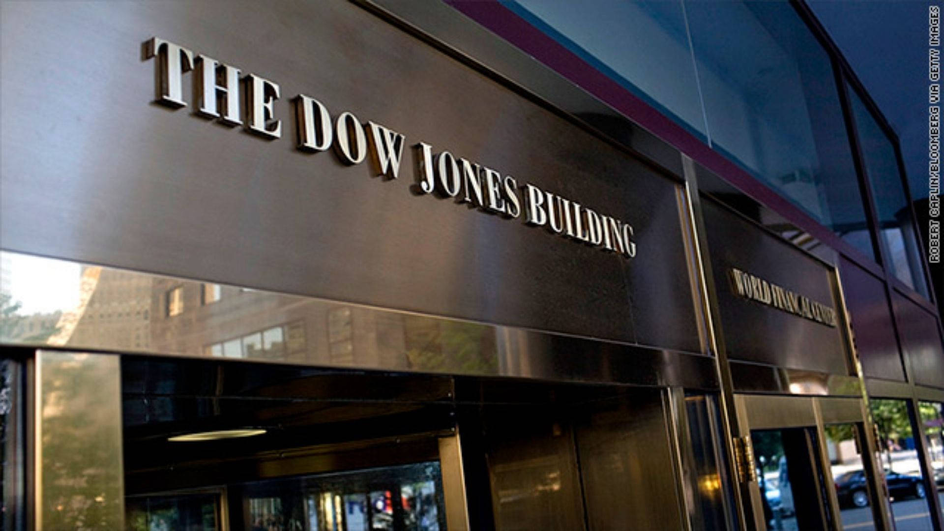 The Dow Jones Building Wallpaper — Close-up of a sleek modern building entrance with 'THE DOW JONES BUILDING' in raised metallic letters on a dark facade.