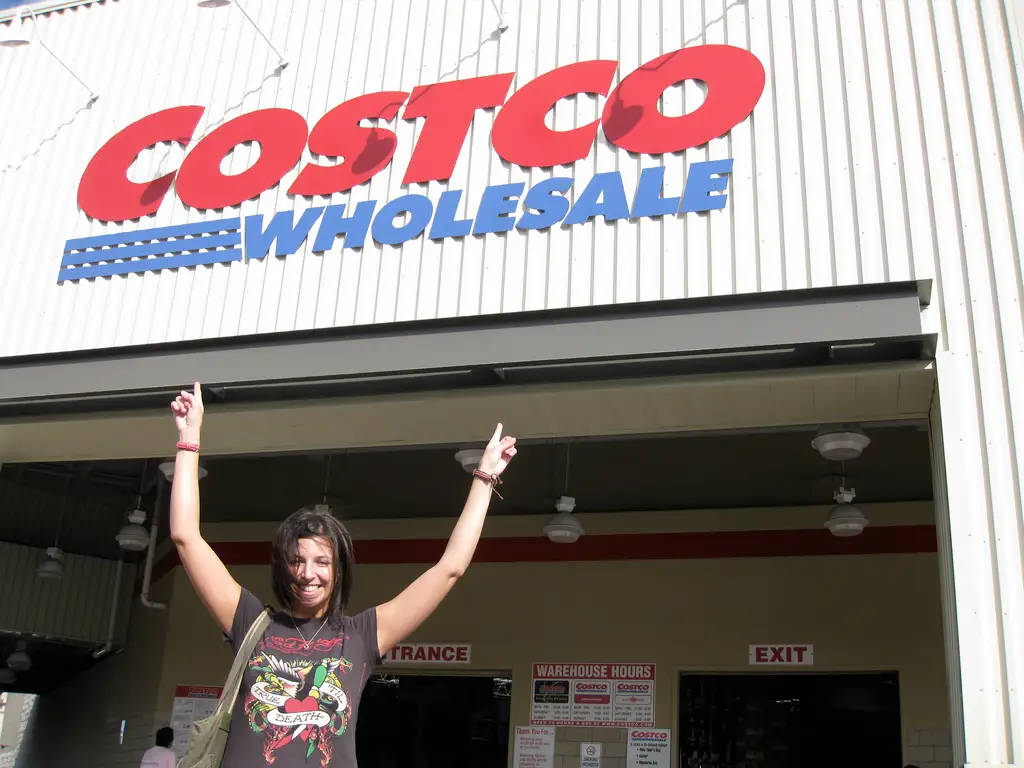 Lady Pointing To Costco Signage Wallpaper
