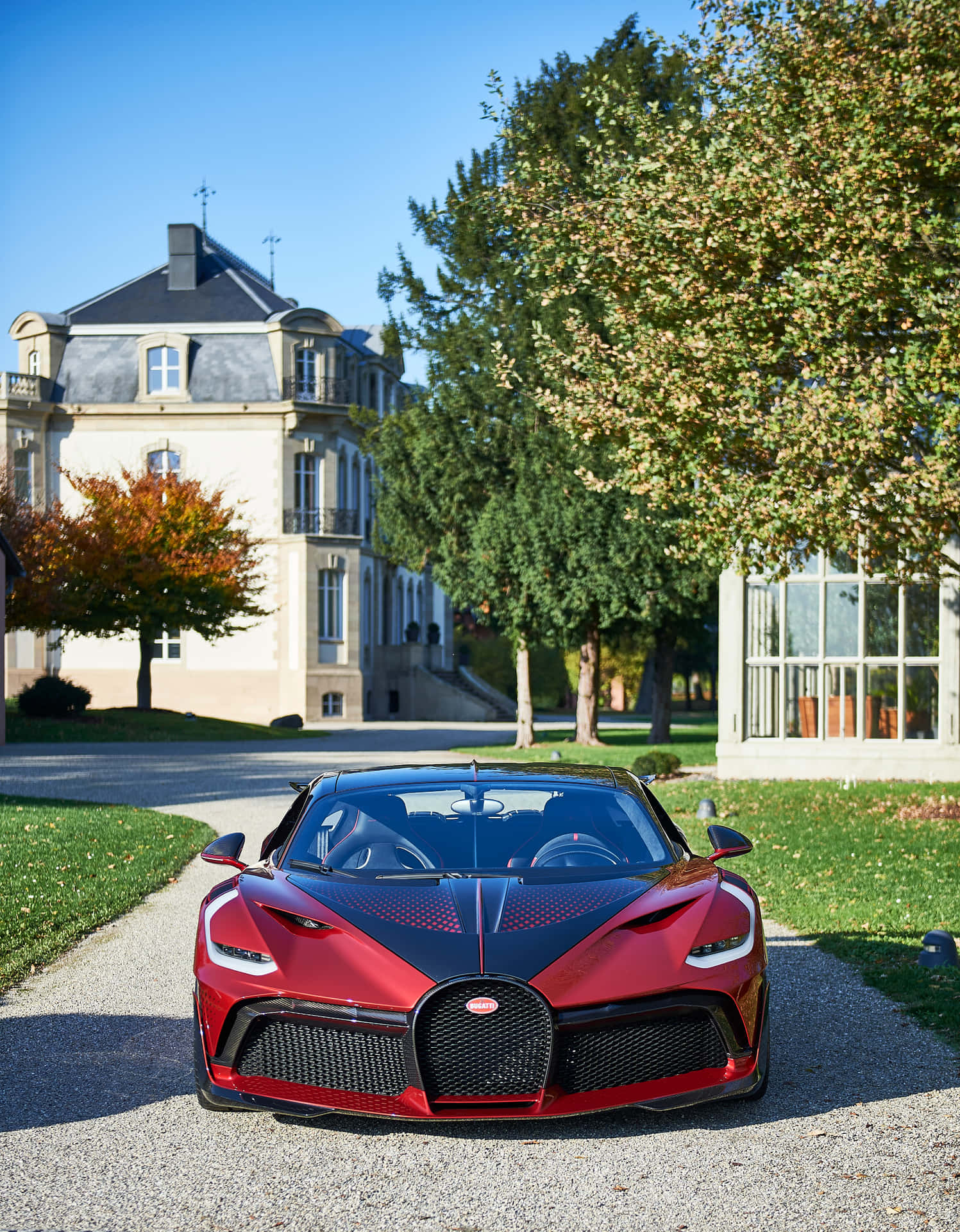 A Red Bugatti Parked In Front Of A House Wallpaper