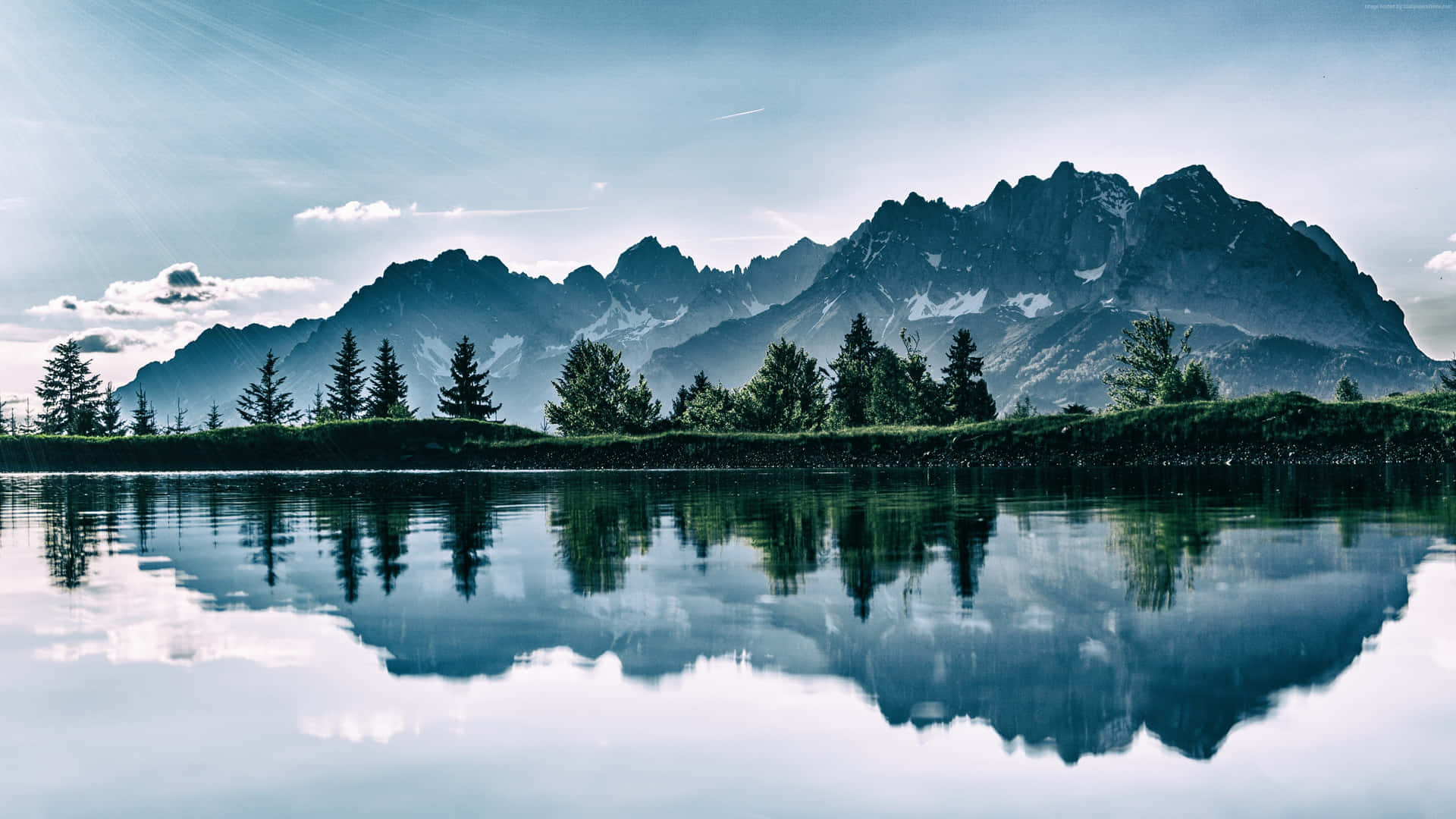 A Mountain Range Is Reflected In The Water